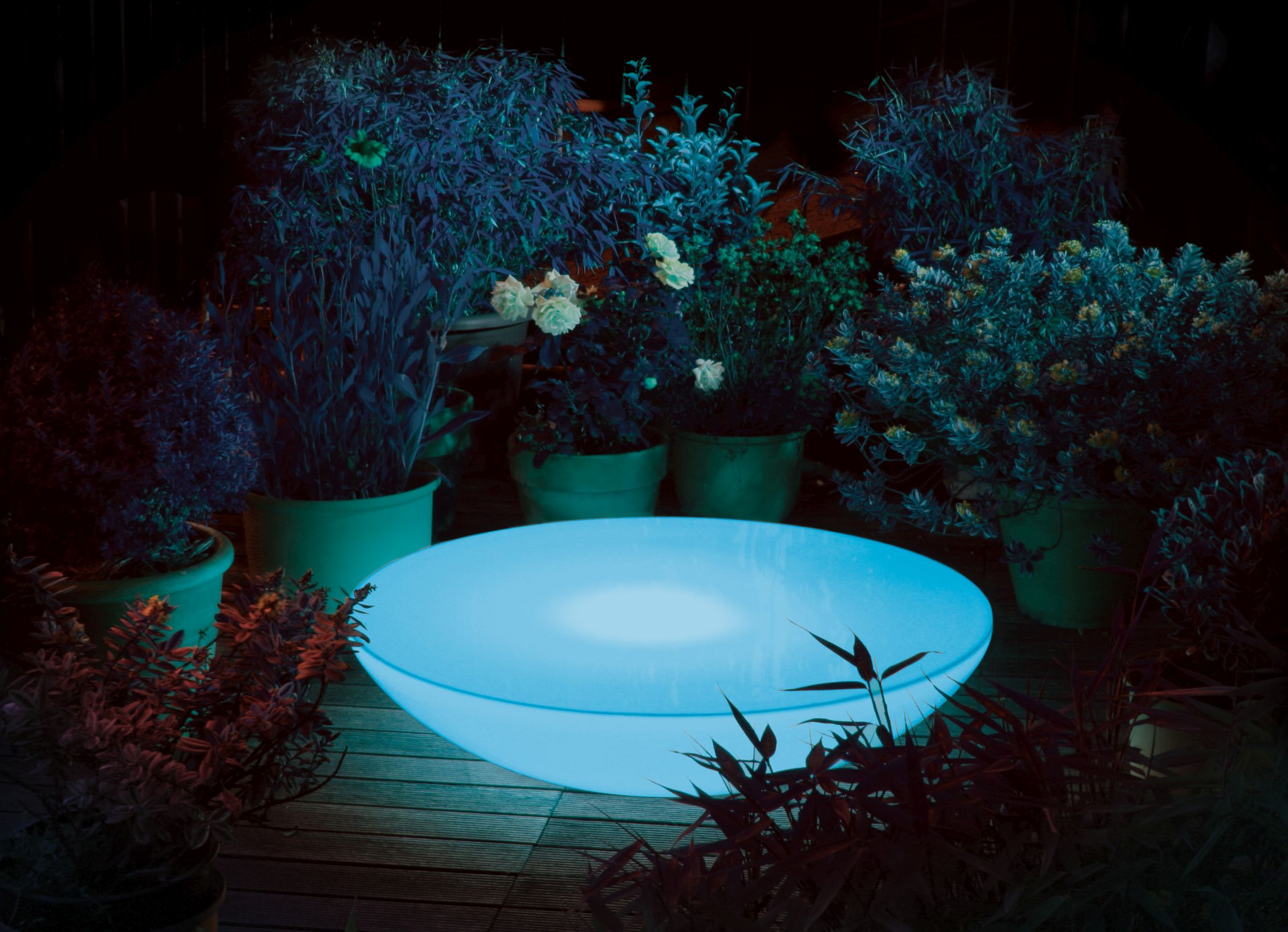 Moree Lounge Beistelltisch mit RGB LED Beleuchtung im Garten bei Nacht.