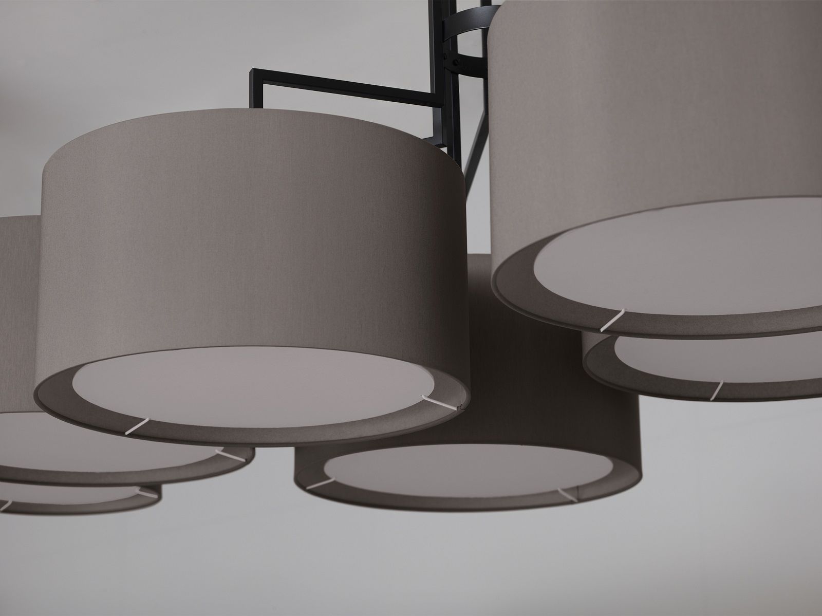 Nahaufnahme der NOON 7 Deckenleuchte von Zeitraum mit grauen Stoffschirmen und schwarzem Gestell.