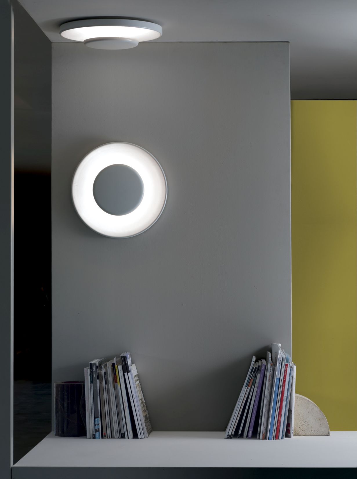 Lunanera Wandleuchte von Martinelli Luce: Runde, moderne Wandlampe mit indirektem Licht und Bücherregal.