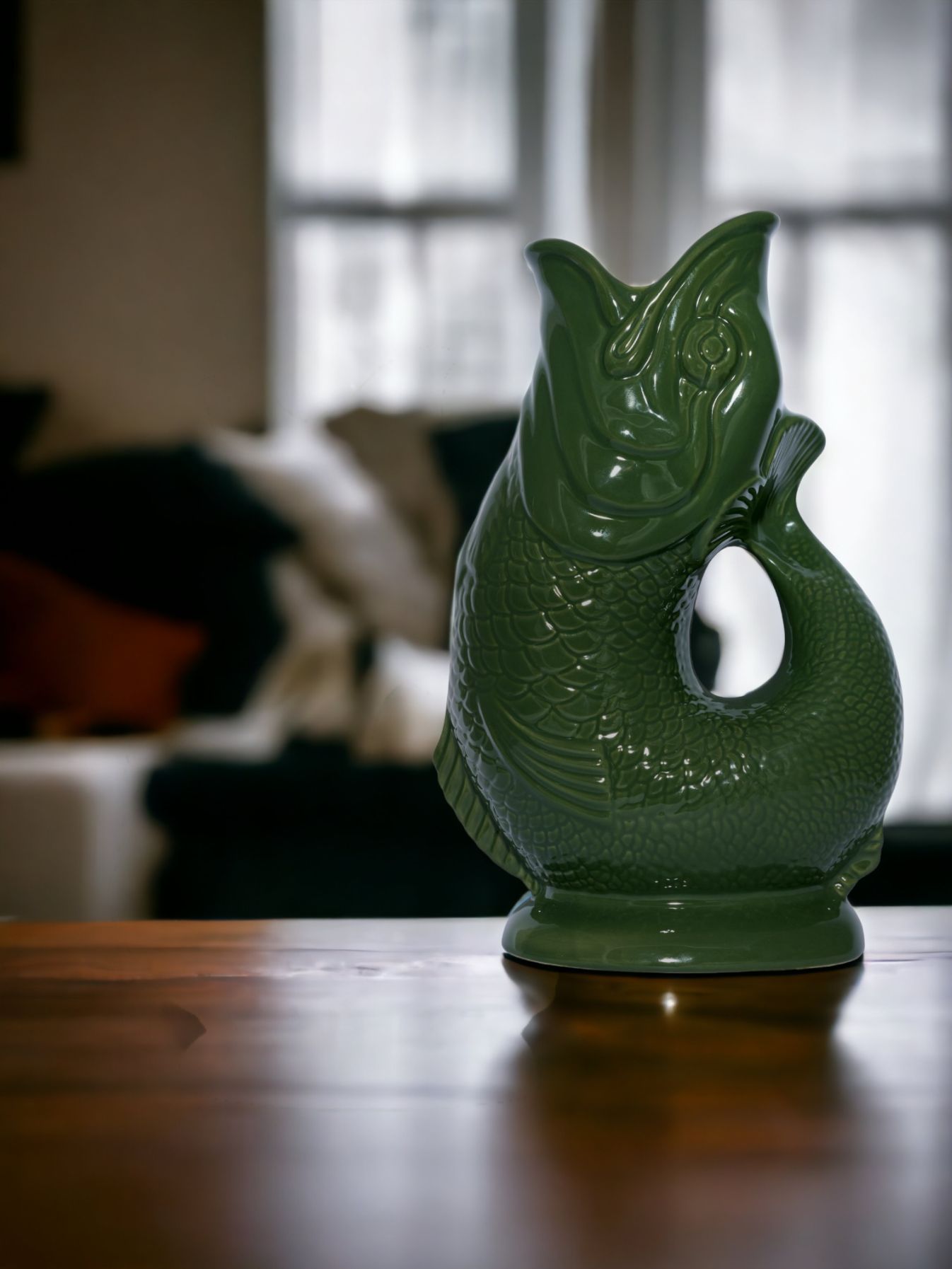 Dunkelgrüne Gluckigluck Karaffe in Fischform, XL, auf einem Holztisch. Dekorative Wasserkaraffe.