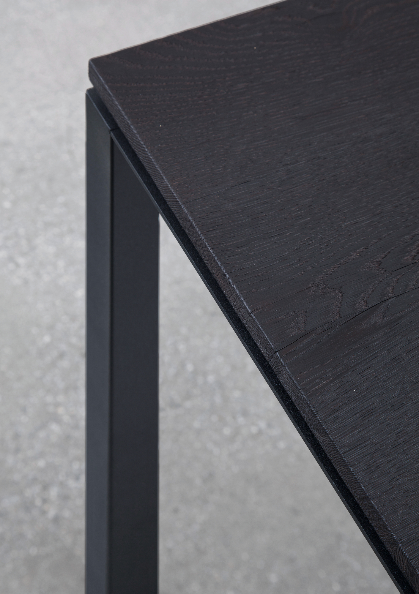 Detailaufnahme S 600 Tisch von Janua: Geköhlte Eiche Tischplatte mit schwarzem Metallgestell.