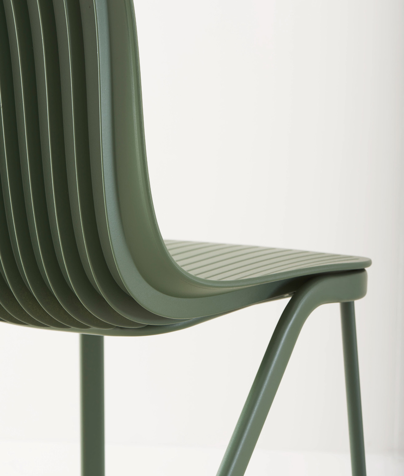 Detailaufnahme: Grüner Dragonfly Stuhl mit Metallbeinen, modernes Design für Esszimmer und Büro.