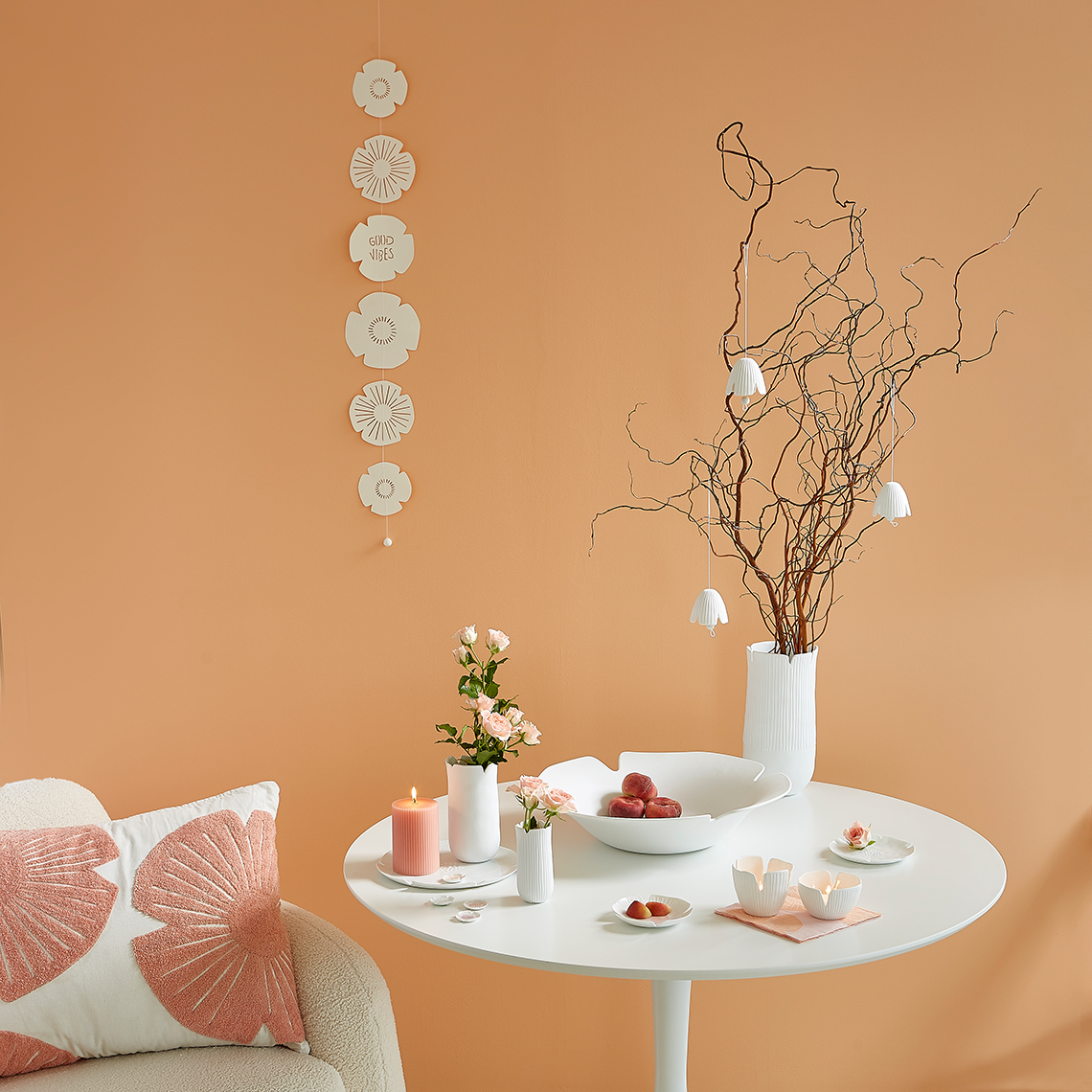 Dekorative "Das Blühende Leben" Schale von Räder auf Tisch mit Blumen, Kerzen und Ästen in Vase.