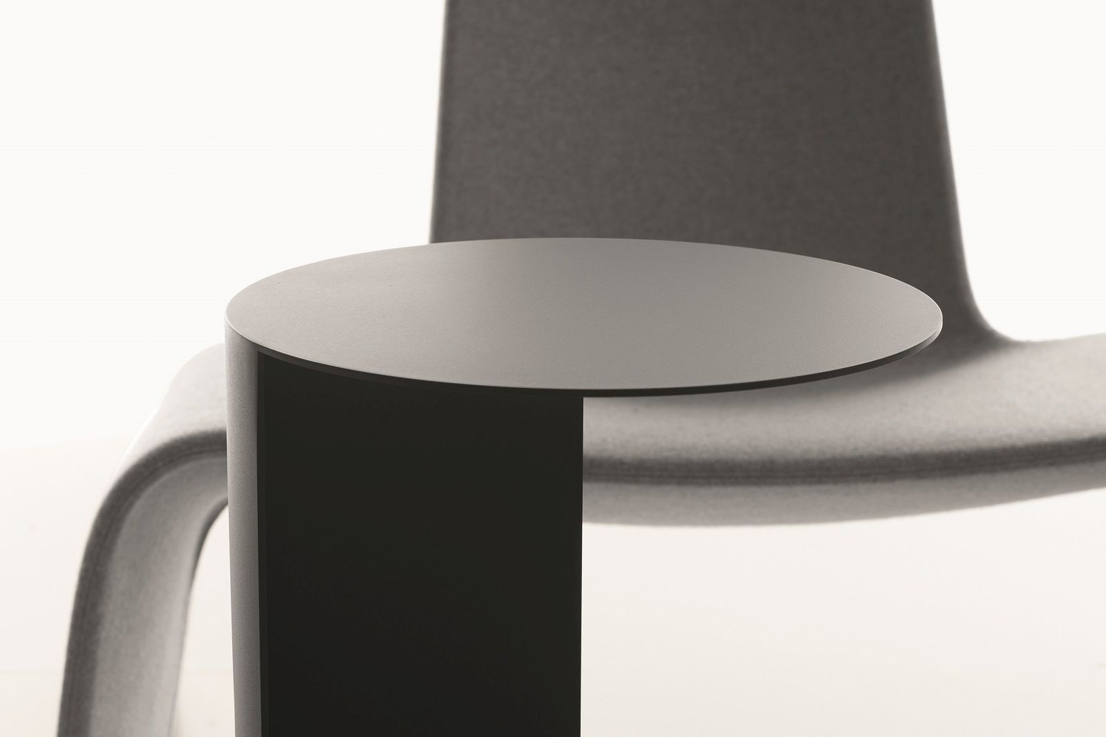 Nahaufnahme des modernen TO Beistelltischs von Plank, minimalistisches Design mit runder Tischplatte und zylindrischem Fuß in Schwarz.