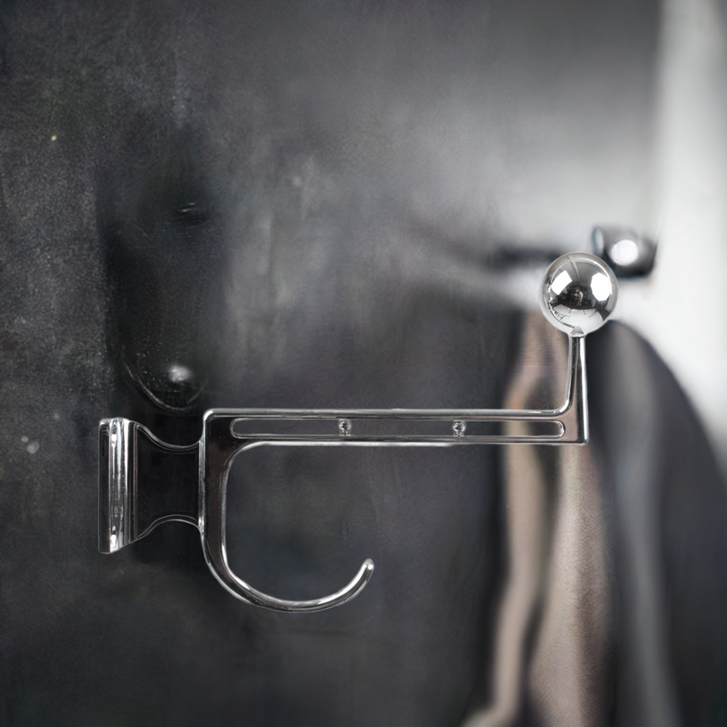 Nahaufnahme eines Large Volker Lang Garderobenhakens aus glänzendem Chrom an einer Wand.