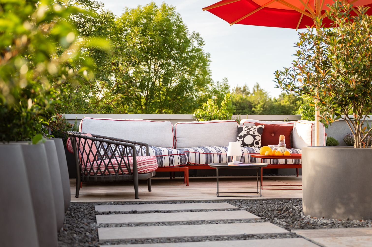 Terrasse mit Outdoor-Sofa, Sessel, Tisch und Sonnenschirm für entspannte Stunden im Freien.