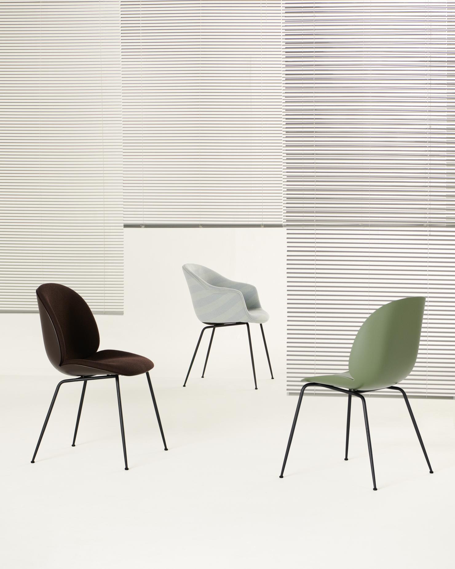 Drei Bat Chairs von Gubi in Braun, Grau und Grün mit schwarzem Gestell.
