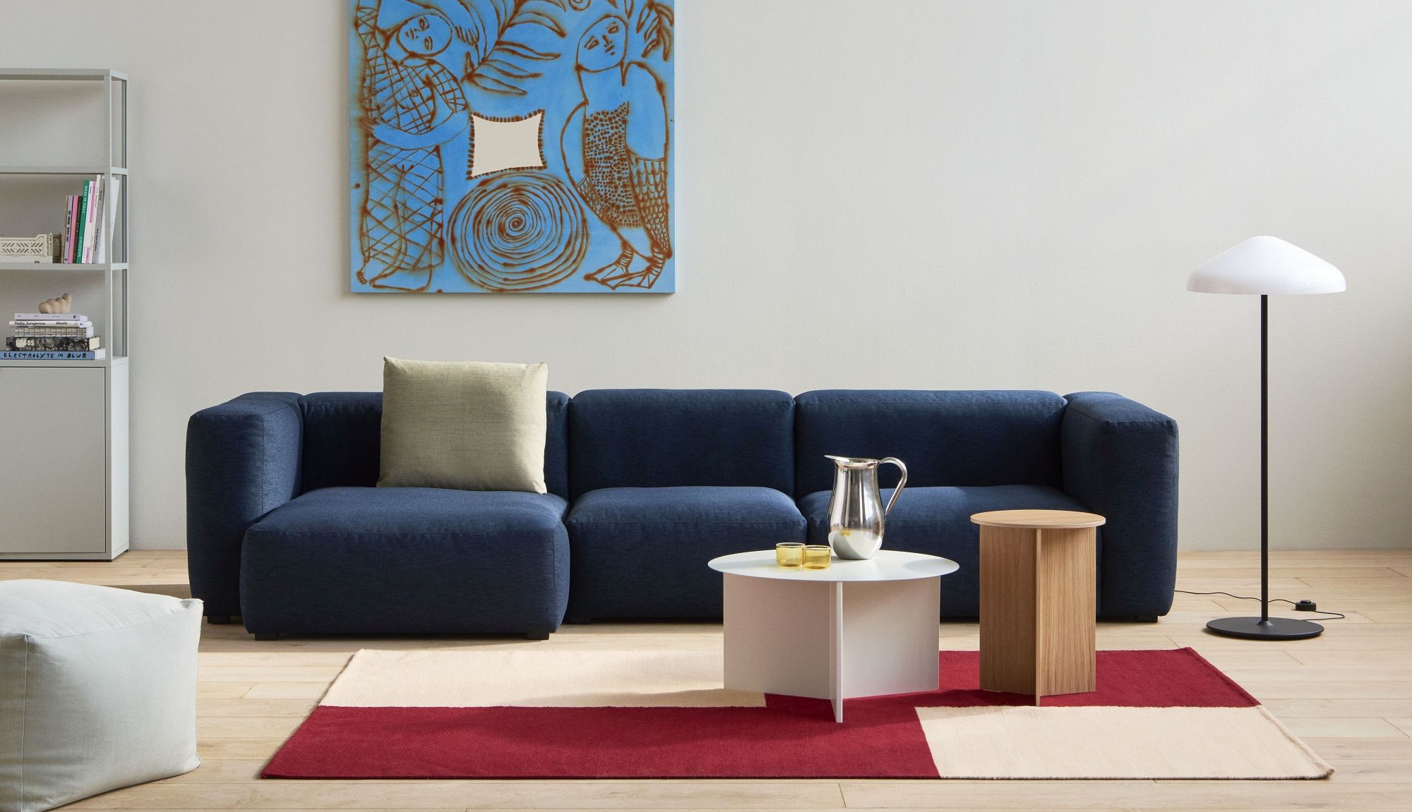 Wohnzimmer mit blauem Sofa, Teppich und Hay Slit Table Beistelltisch aus Holz und Metall.