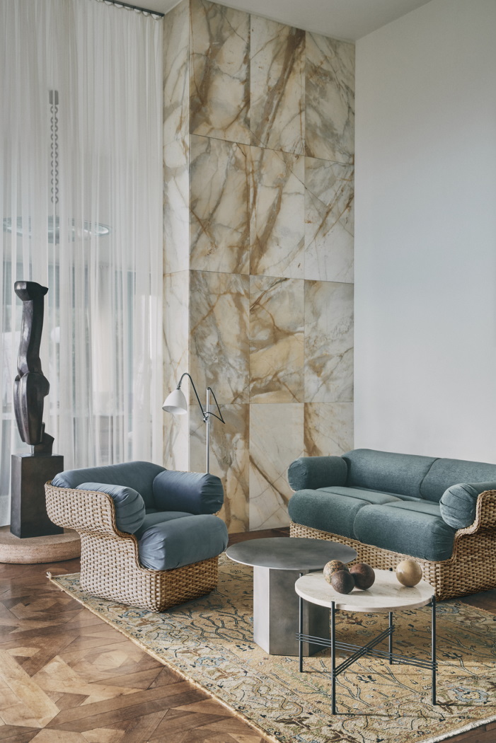 TS Coffee Table 55 Couchtisch von Gubi in einem Wohnzimmer mit Sofa und Sessel.