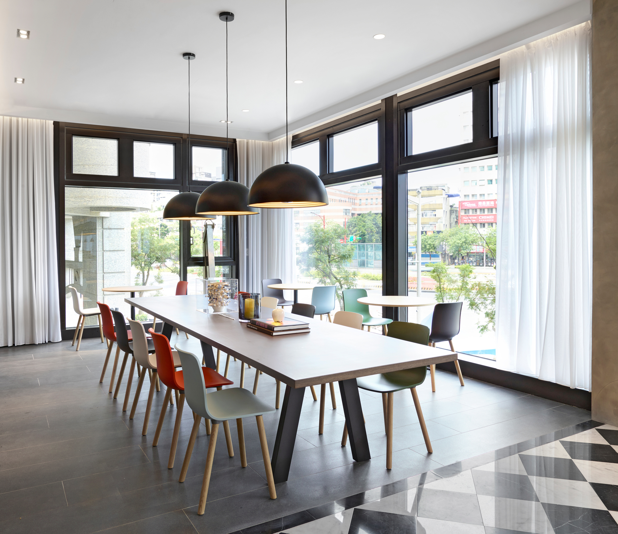 Esszimmer mit langem Tisch und Vitra Hal Ply Wood Stühlen in verschiedenen Farben.