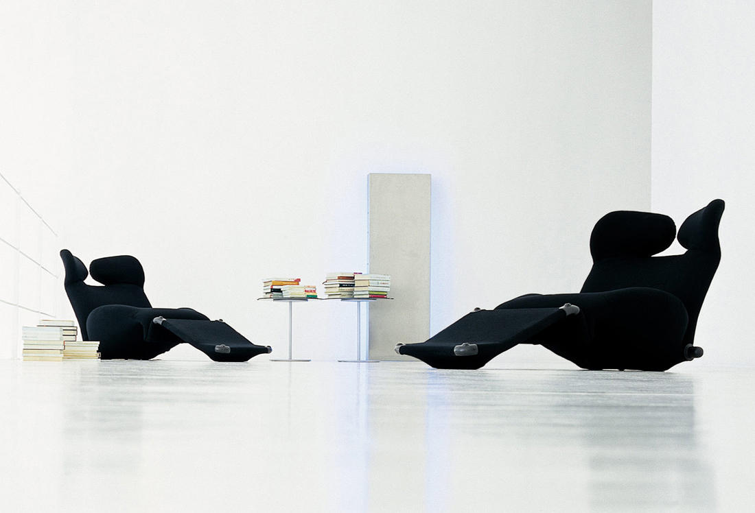 Zwei schwarze 111 Wink Sessel von Cassina in minimalistischem Raum mit Büchern.