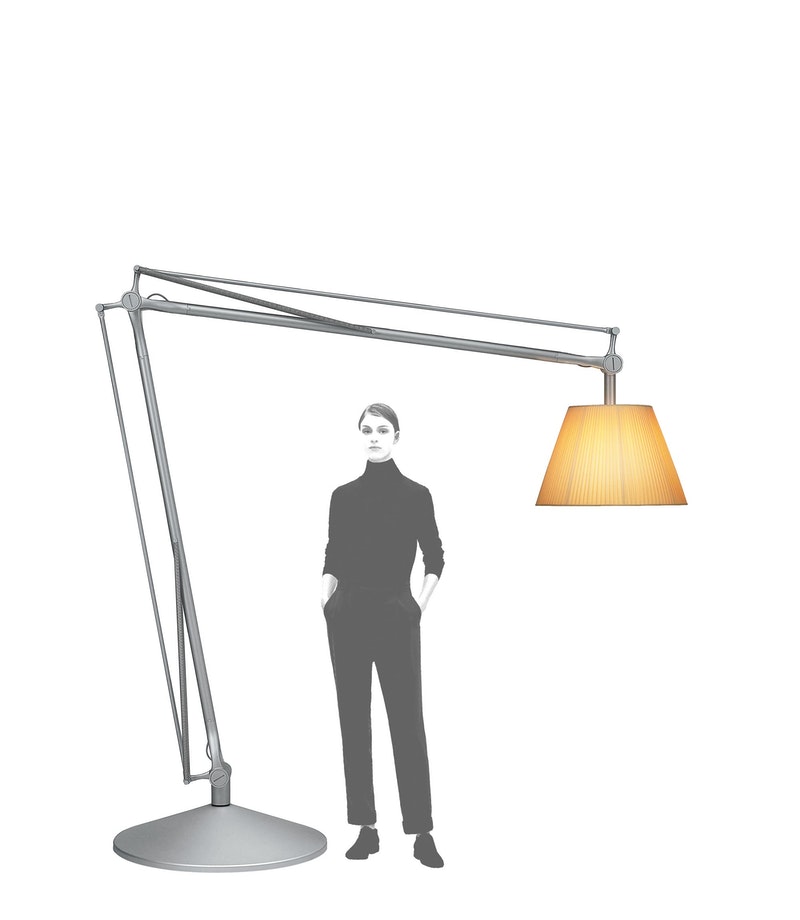 Superarchimoon Stehleuchte von Flos: Große, graue Bogenlampe mit plissiertem Lampenschirm und Person zum Größenvergleich.