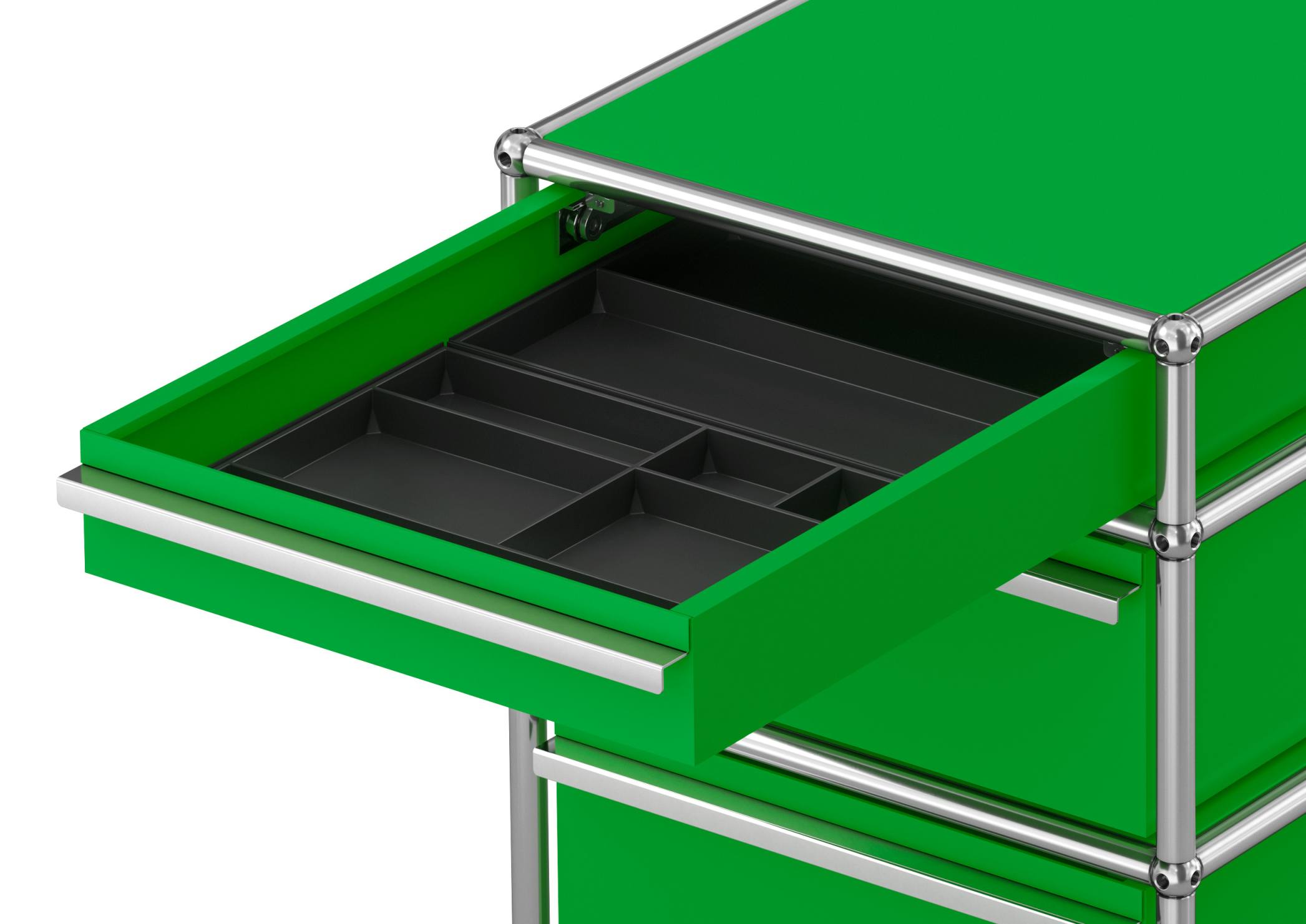 USM Haller Rollcontainer in Grün mit drei Schubladen, eine Schublade ist geöffnet und zeigt Facheinteilung.
