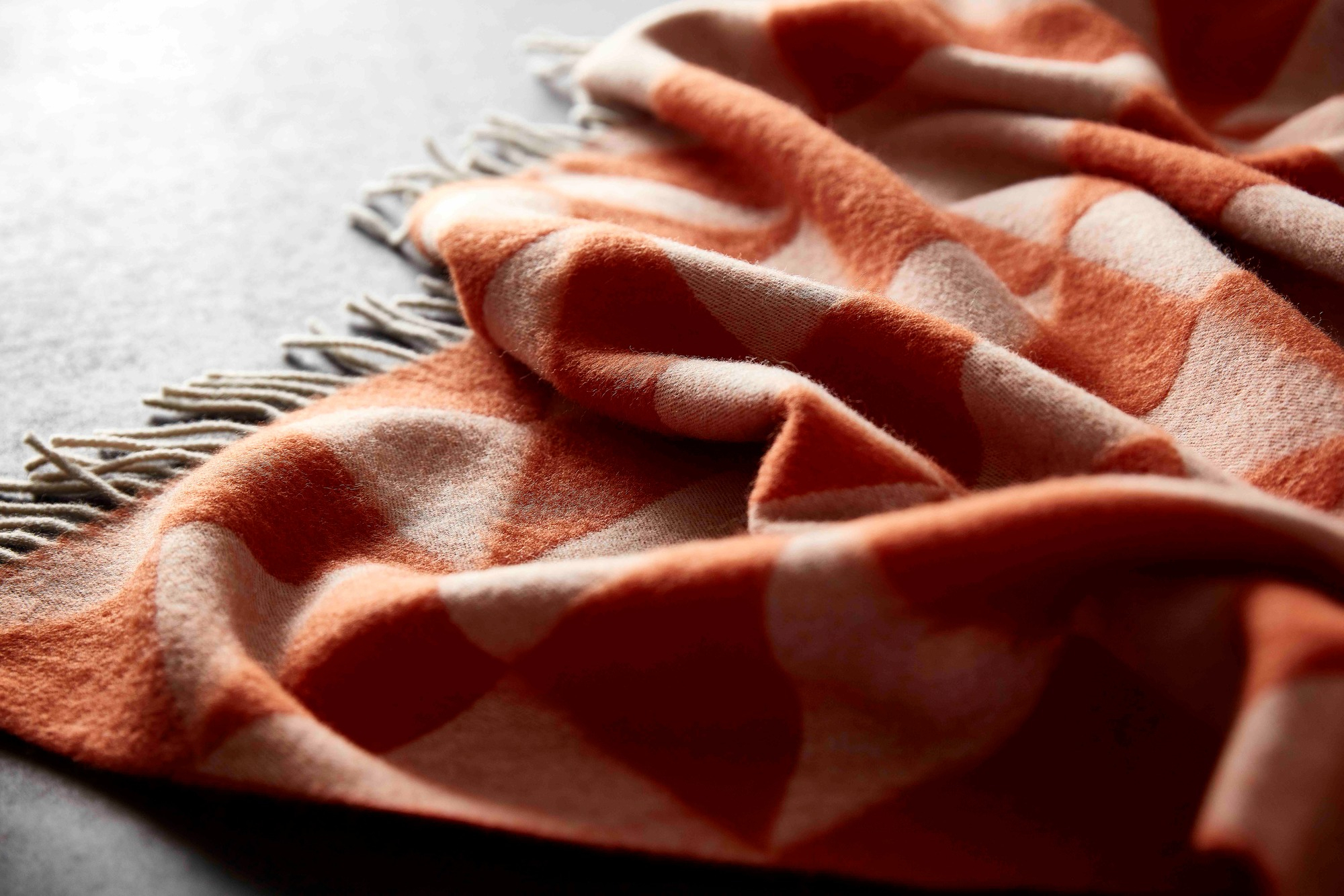 Detailaufnahme des Verpan Überwurfs "Mirror Throw" in Sand mit Fransen und grafischem Muster.