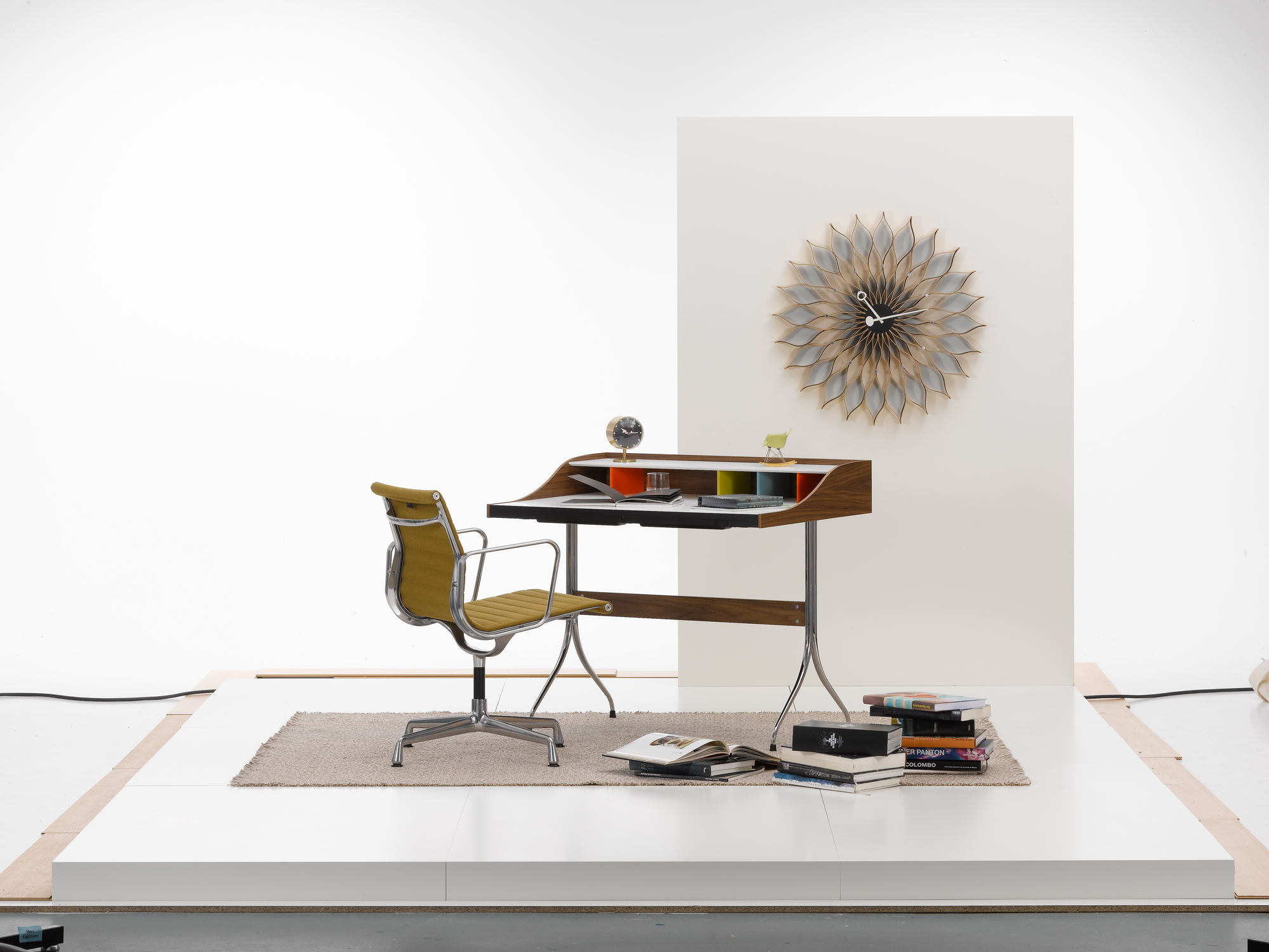 Vitra Home Desk mit Bürostuhl und Wanduhr in einem minimalistischen Studio-Setup. Moderner Schreibtisch für das Homeoffice.