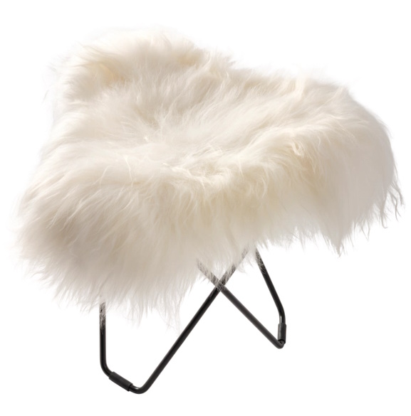 Iceland Flying Goose Schaffellhocker: Detailansicht des weißen, flauschigen Fellhockers mit schwarzem Metallgestell.