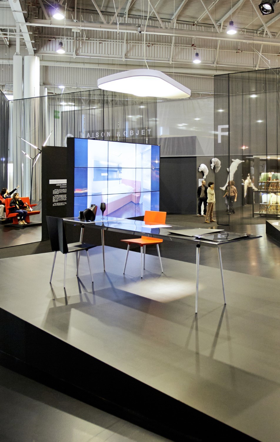 Helle D71PV Petale LED Pendelleuchte von Luceplan über einem modernen Tisch mit Stühlen.