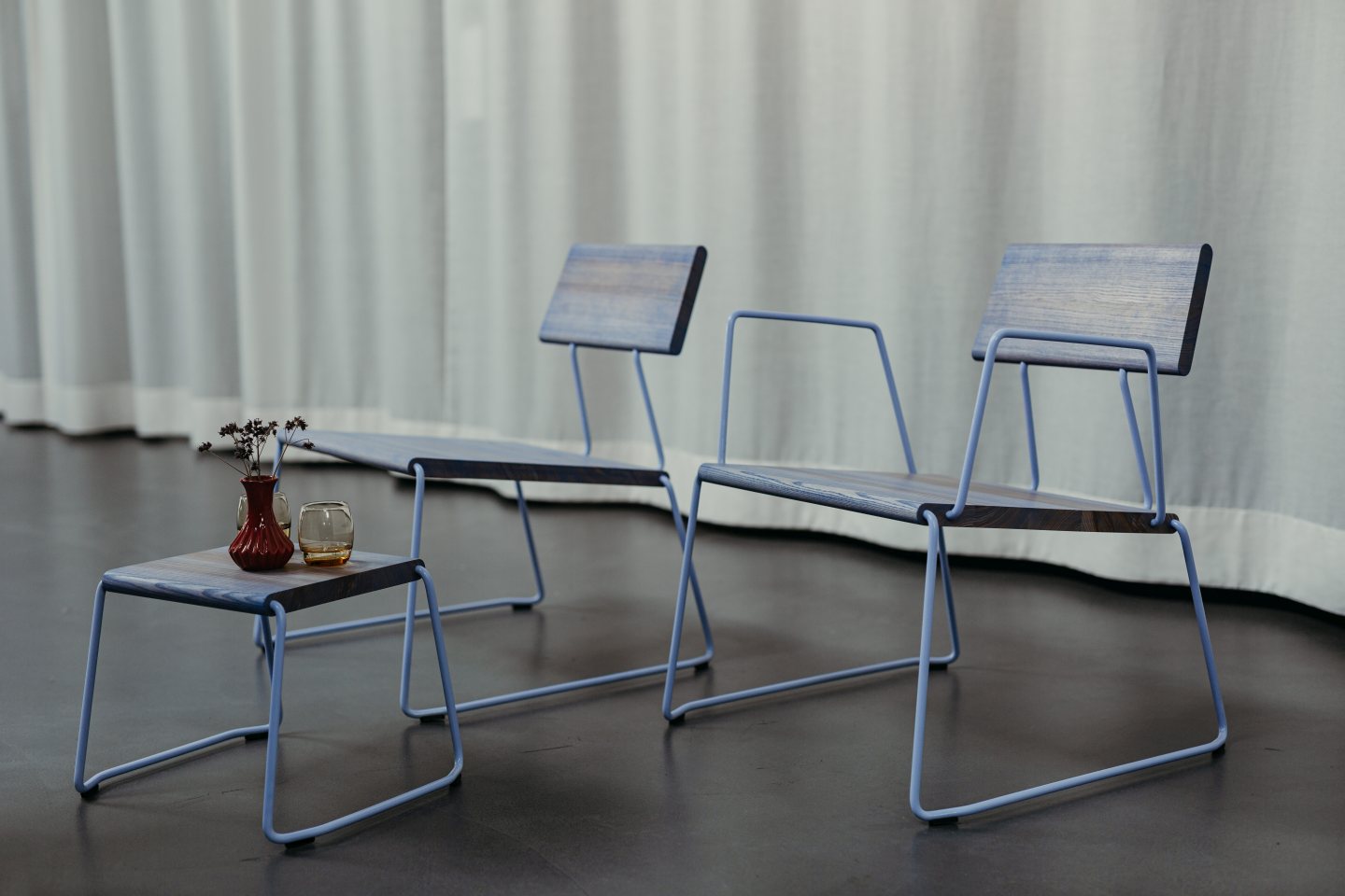 D:008 Loungechair mit Armlehnen von Fuchs & Habicht: Zwei blaue Holzstühle und Beistelltisch.