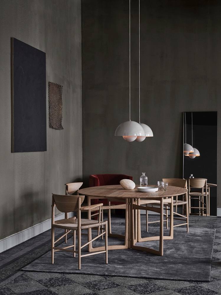 Drawn HM4 Stuhl mit Armlehnen von AndTradition an einem Esstisch mit Stühlen.