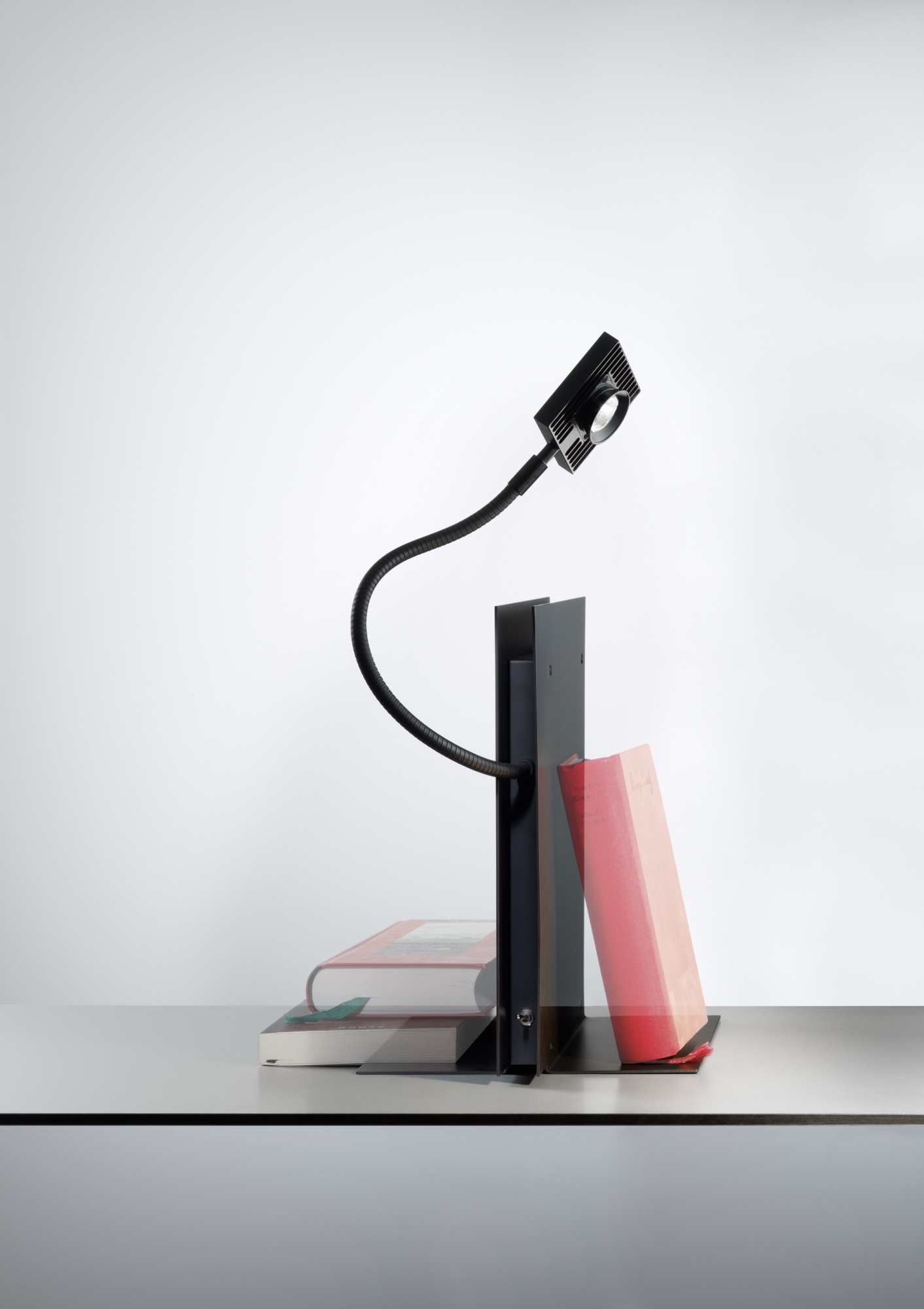 LED's Oskar Regalleuchte von Ingo Maurer beleuchtet Bücher mit flexiblem Arm und modernem Design.