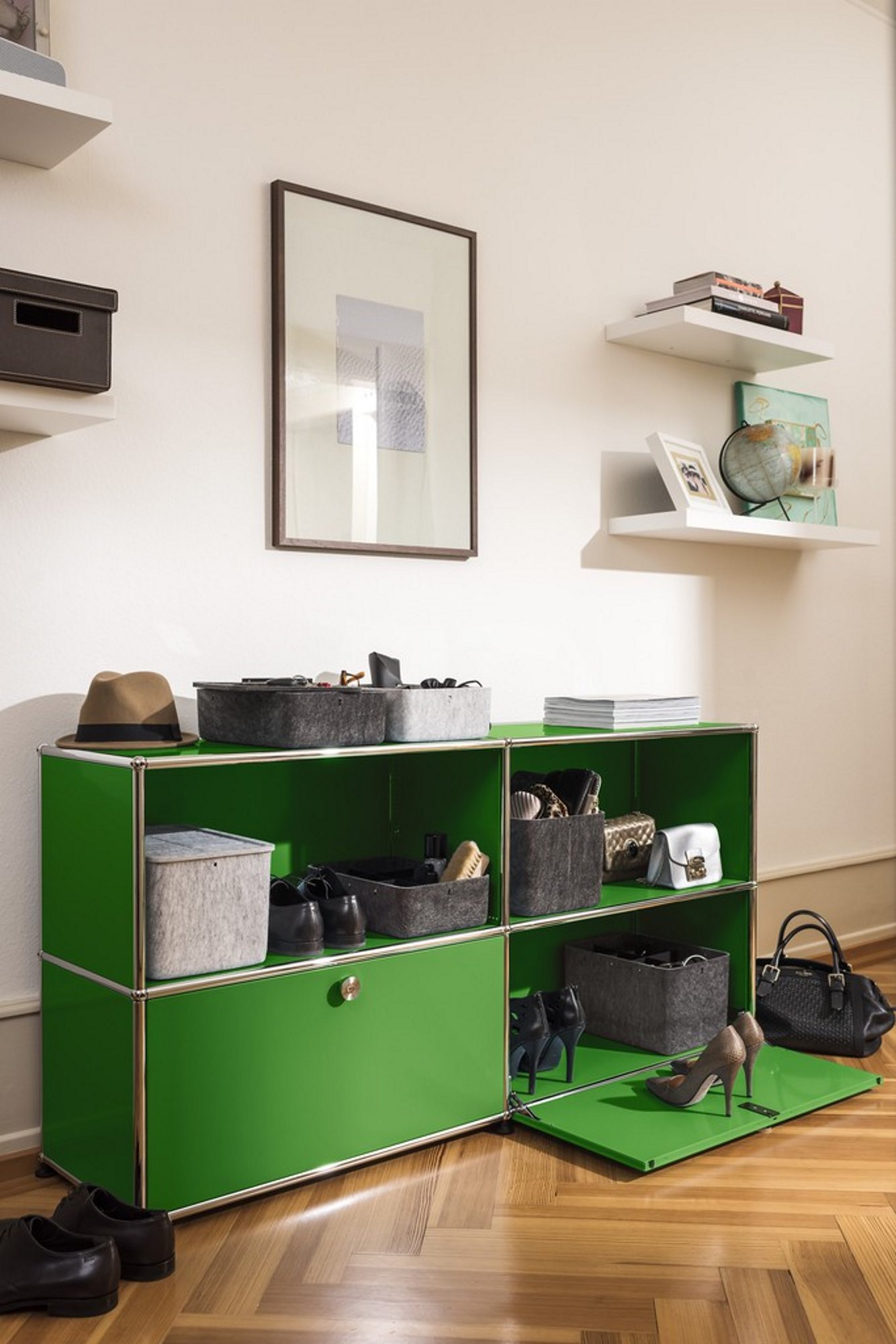 USM Haller Inos Box hellgrau in grüner Regalkombination, ideal zur Aufbewahrung von Schuhen und Accessoires.