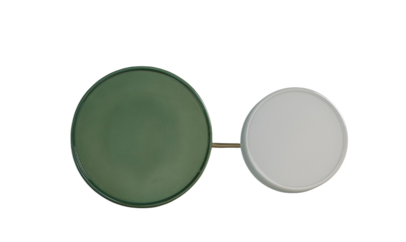 Caramel Wandleuchte von Marset mit zwei runden Lampenschirmen in Grün und Weiß, verbunden durch Gold.