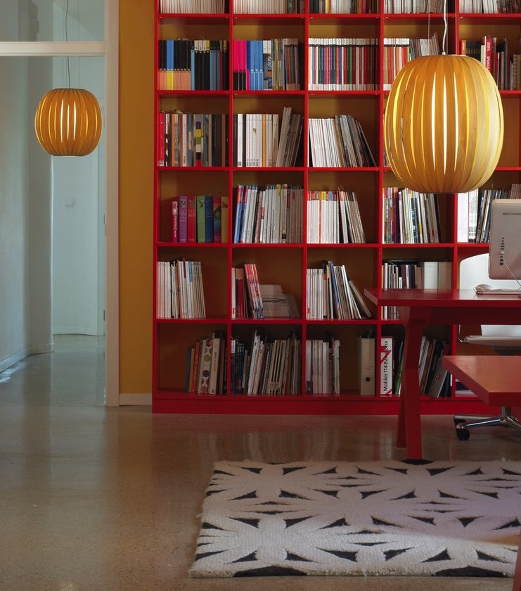 Zwei hölzerne Pod Pendelleuchten von LZF Lamps in einem modernen Wohnzimmer mit Bücherregal.