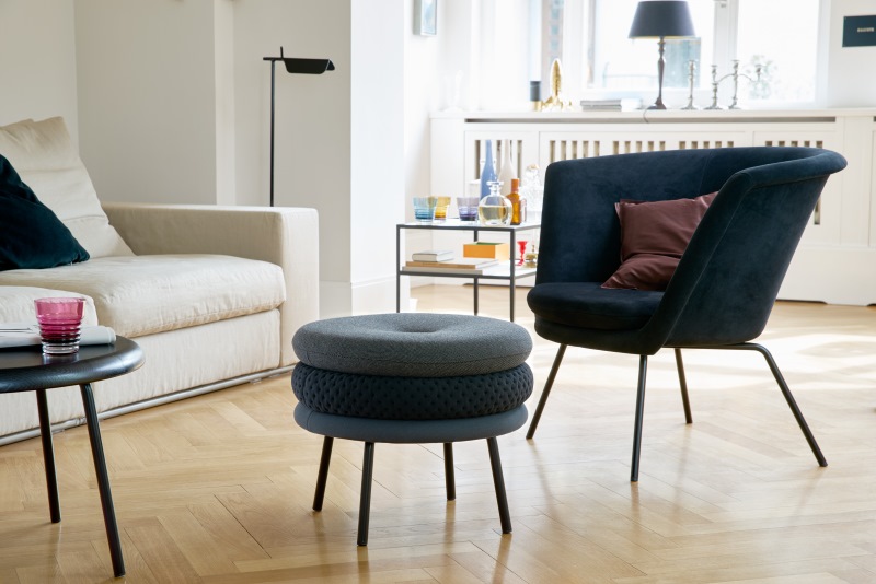 H57 Sessel von Richard Lampert in Dunkelblau mit passendem Hocker im modernen Wohnzimmer.
