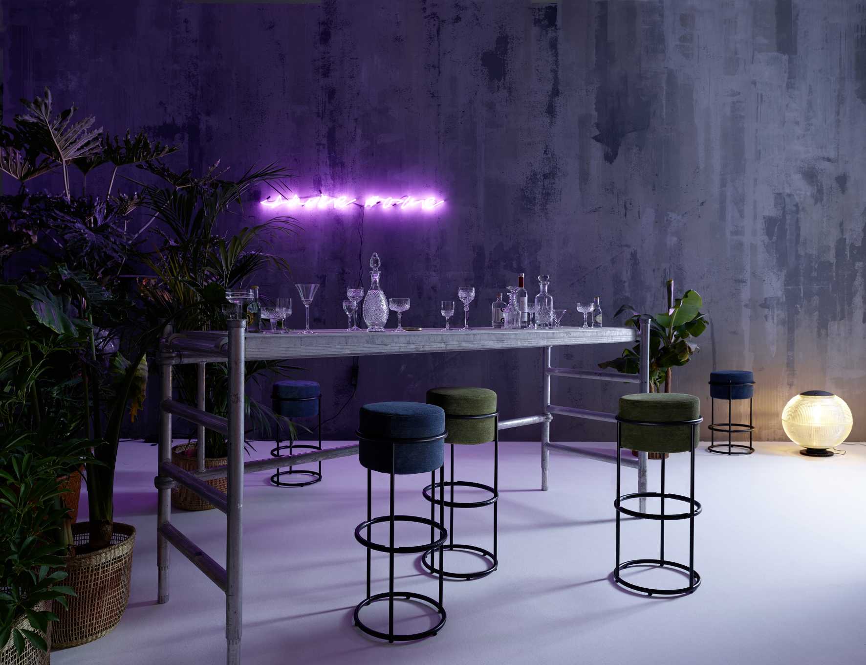 Drop Barhocker von Cor, verschiedene Farben, mit schwarzem Metallgestell vor einer Bar.