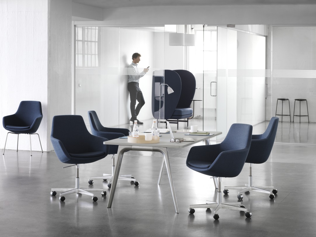Büro mit mehreren blauen Fritz Hansen Sesseln, darunter der JH1001 Plenum Sessel, und einem Tisch.