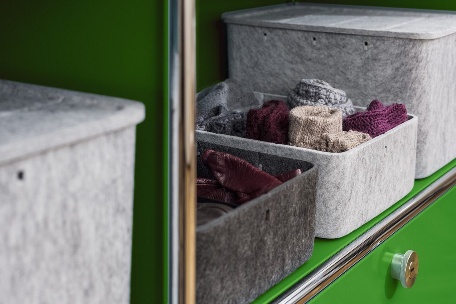 USM Haller Inos Box hoch, graue Filzboxen mit Kleidung im grünen USM Möbelbausystem.
