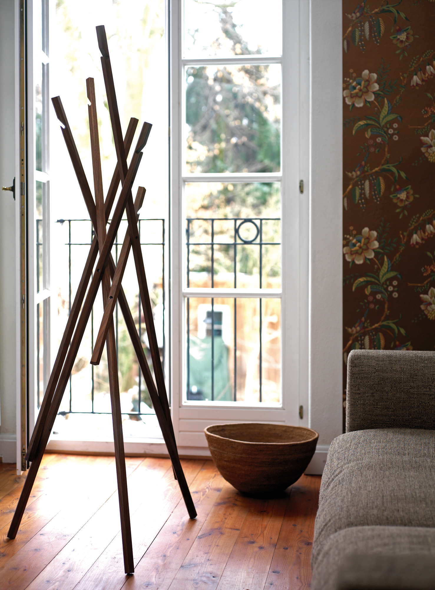 Sticks Garderobenständer aus Nussbaumholz vor einem Fenster. Moderne Garderobe für Flur und Eingangsbereich.