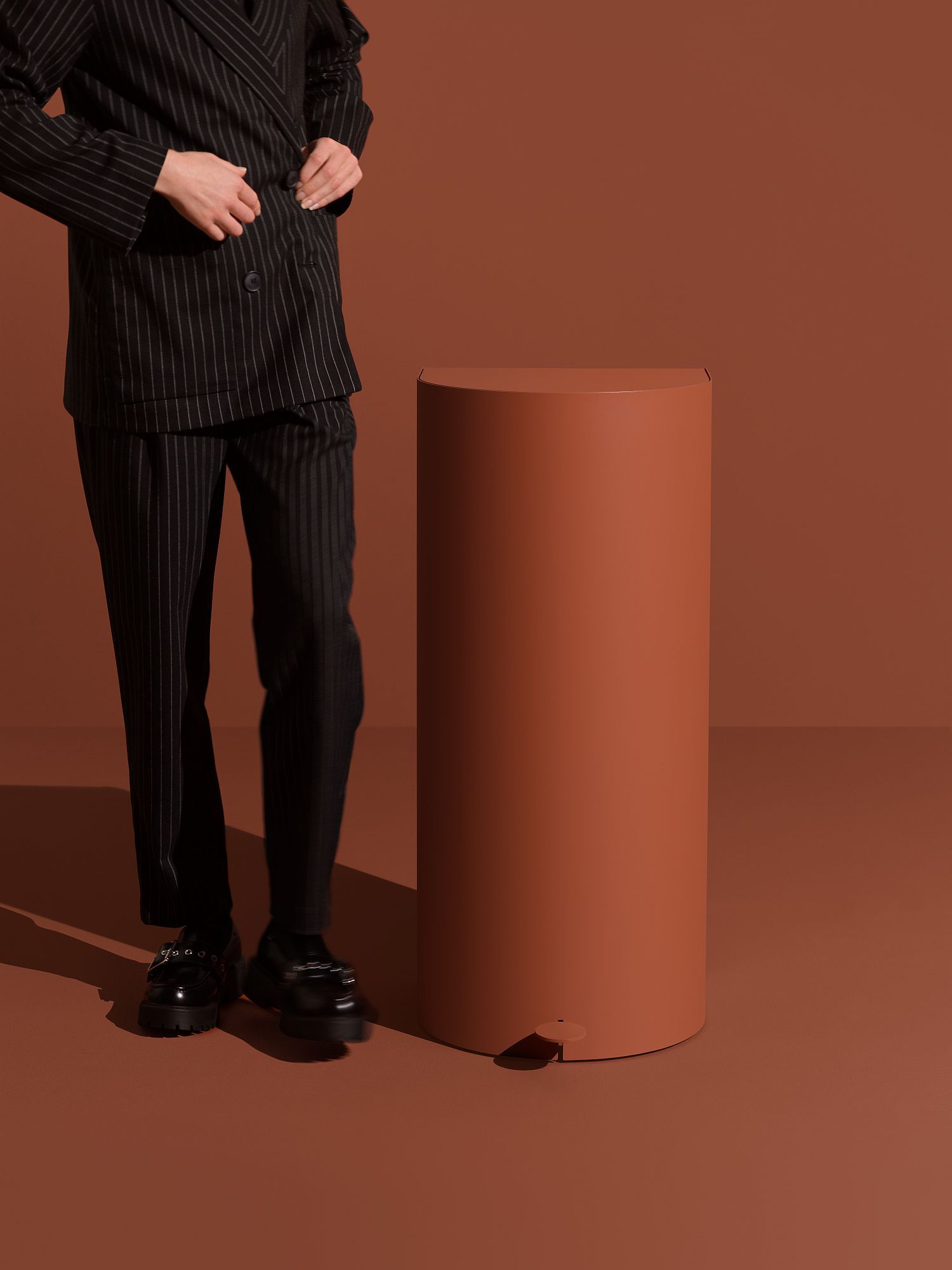 Pelican Pedal bin Treteimer: Runder, brauner Abfalleimer mit Fußpedal neben einer Person.