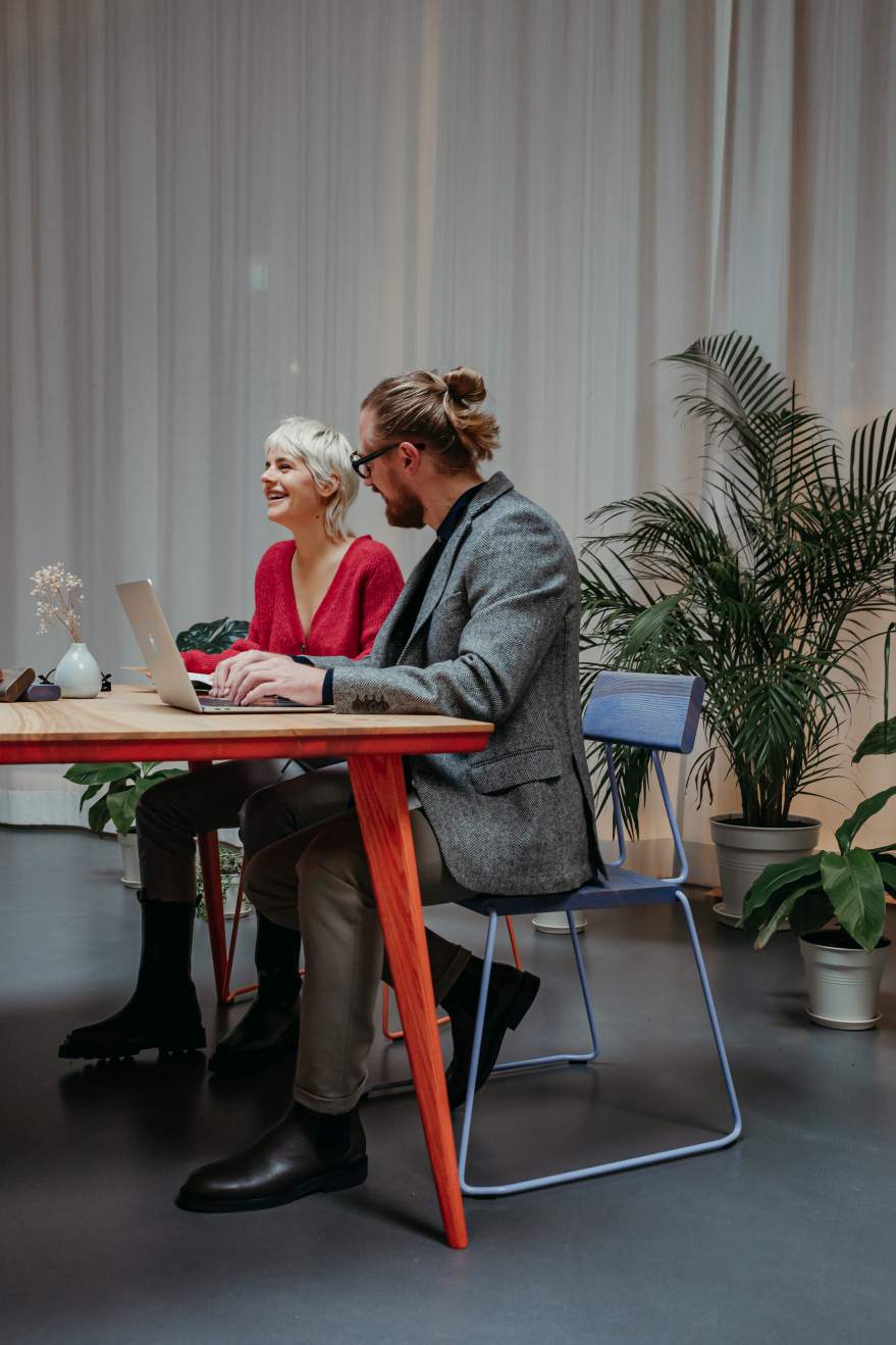 Zwei Personen sitzen an einem Tisch auf einem Stuhl, ähnlich dem D:005 Stuhl.