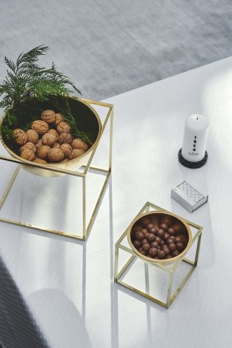 Zwei goldene Deko-Schalen auf quadratischem Gestell, gefüllt mit Nüssen und Schokoladenkugeln, moderne Tischdekoration.