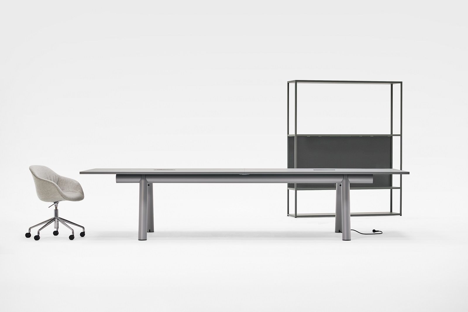 Boa Table von Hay, ein grauer Konferenztisch mit Stuhl und Regal im minimalistischen Design.