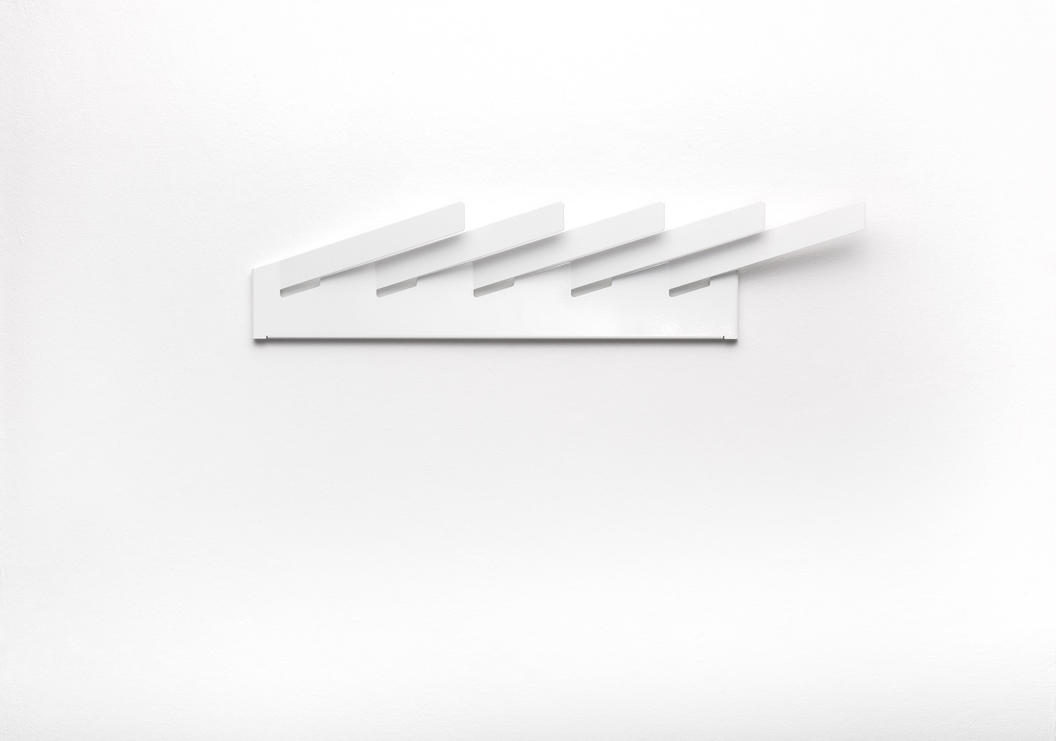 Weißer Mr_Magazinhalter von Müller Möbelwerkstätten an einer weißen Wand. Modernes Design für Zeitschriften und Magazine.