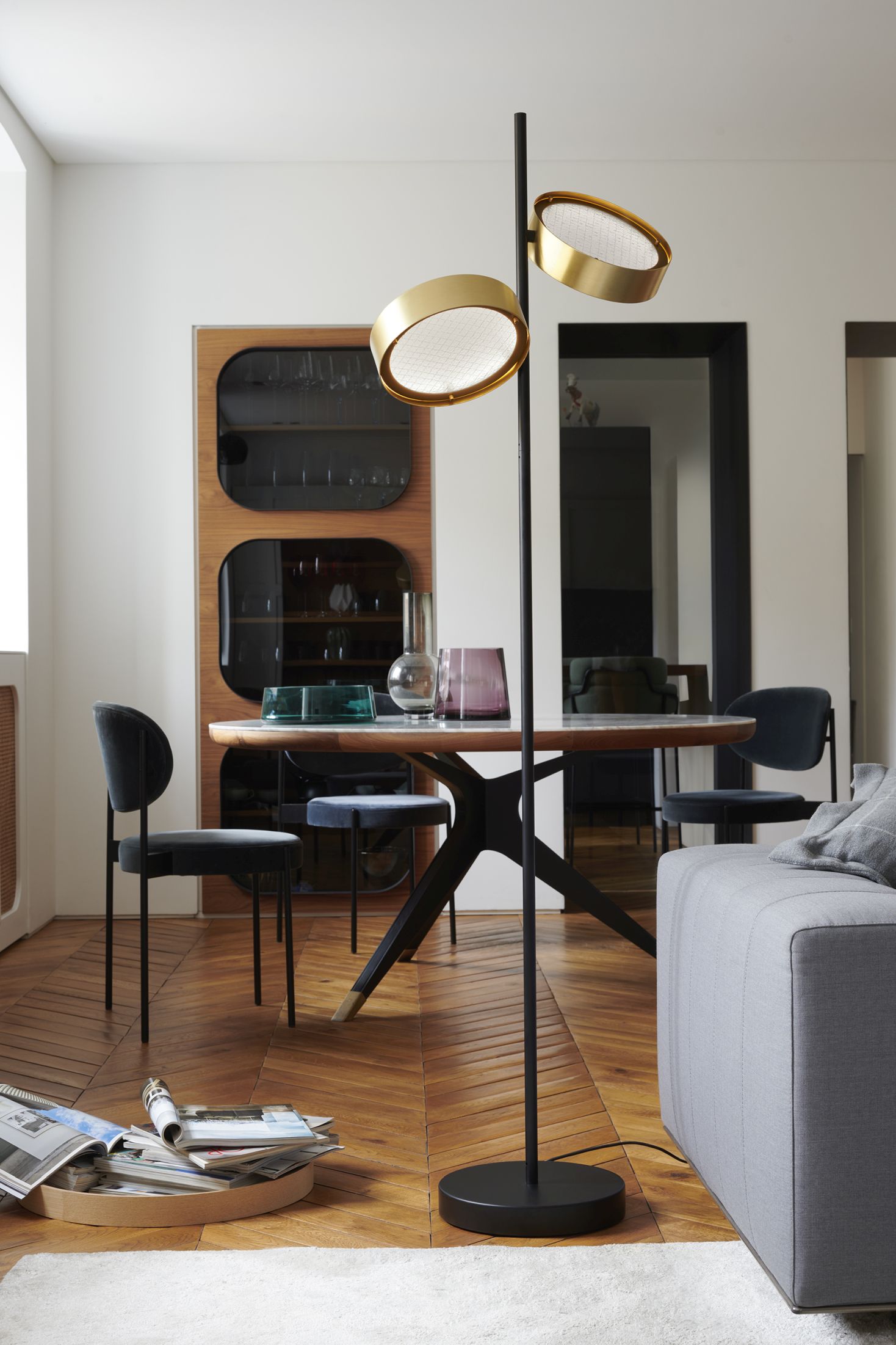 Berlin 323 Stehleuchte von Oluce im modernen Wohnzimmer mit Esstisch und Sofa.