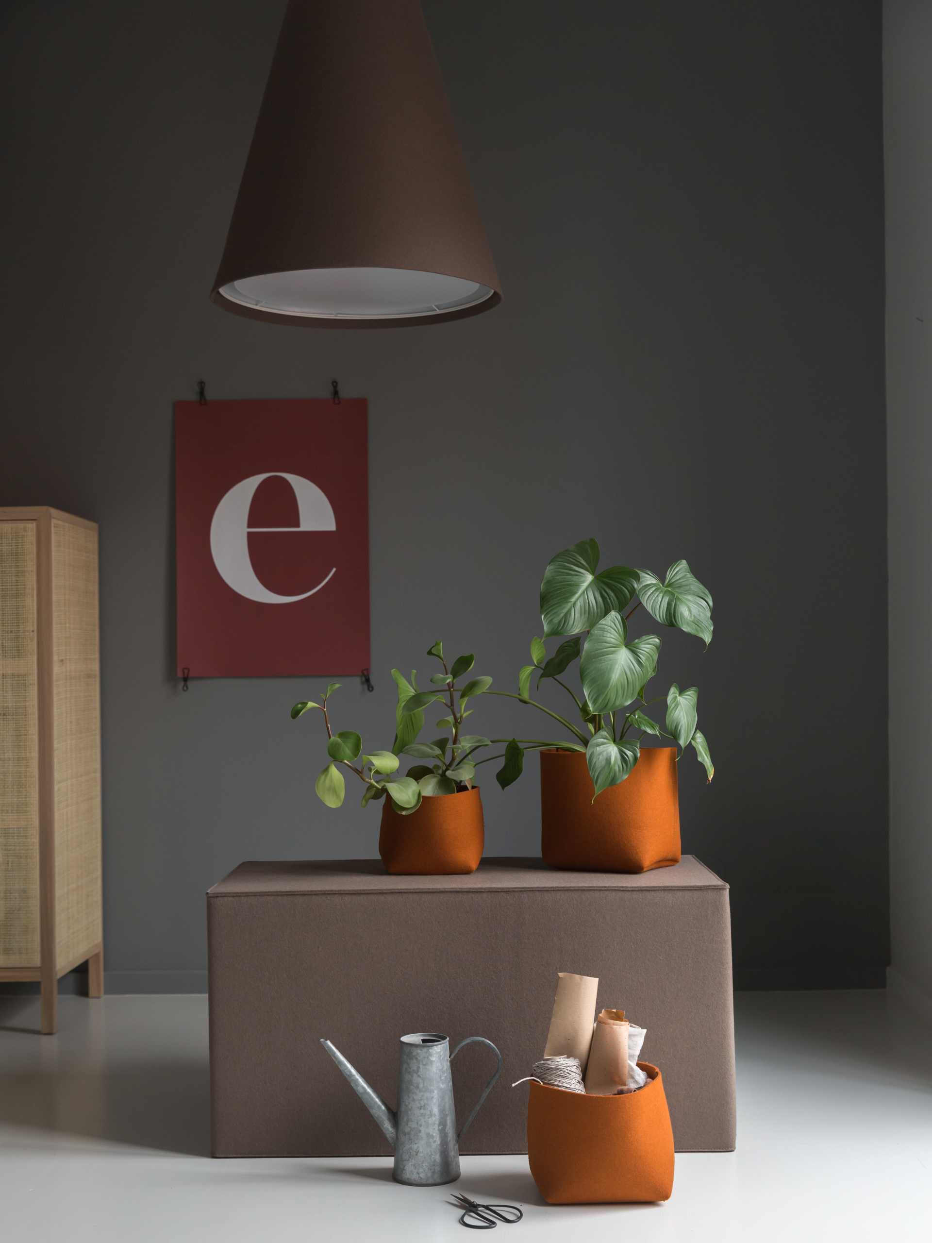 Hey Sign Quader Hocker als Sitzmöbel oder Ablagefläche, dekoriert mit Pflanzen und Accessoires.