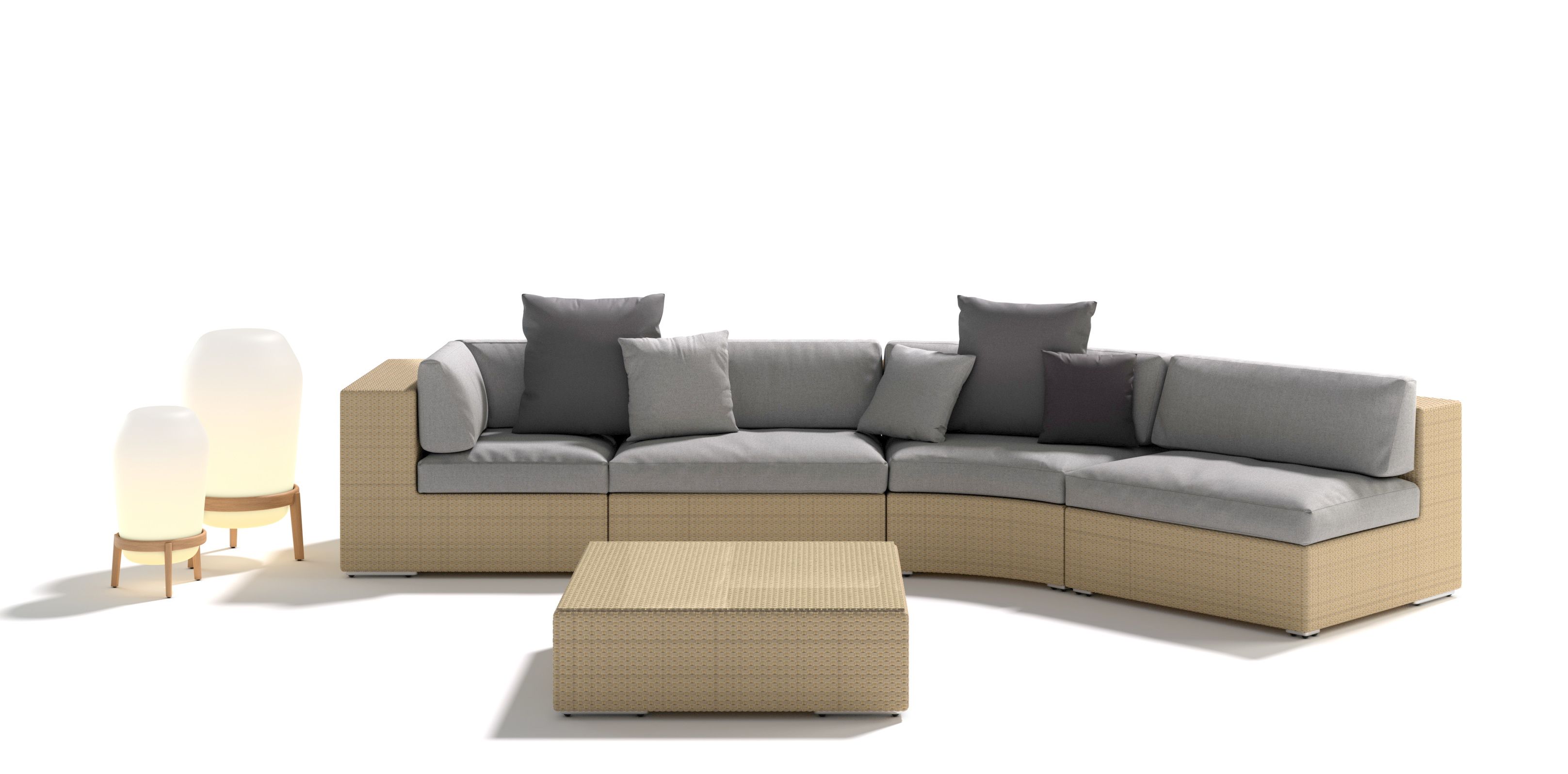 Dedon Lounge Setting mit Rattansofa, Couchtisch und zwei Lampen für den Außenbereich.