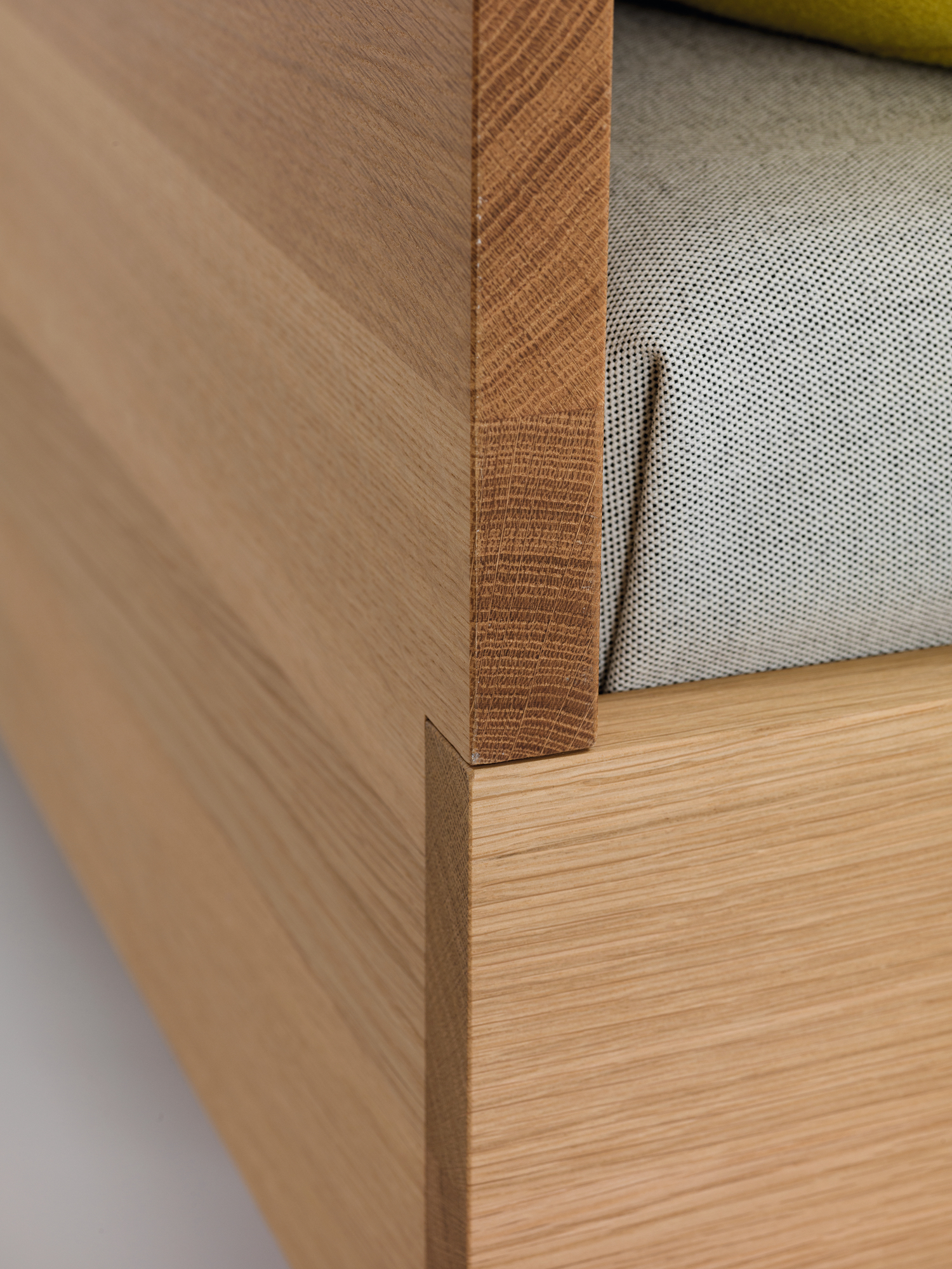 Detailaufnahme vom Simple HI Holzbett Zeitraum: Holzstruktur und Polsterung des Bettes.