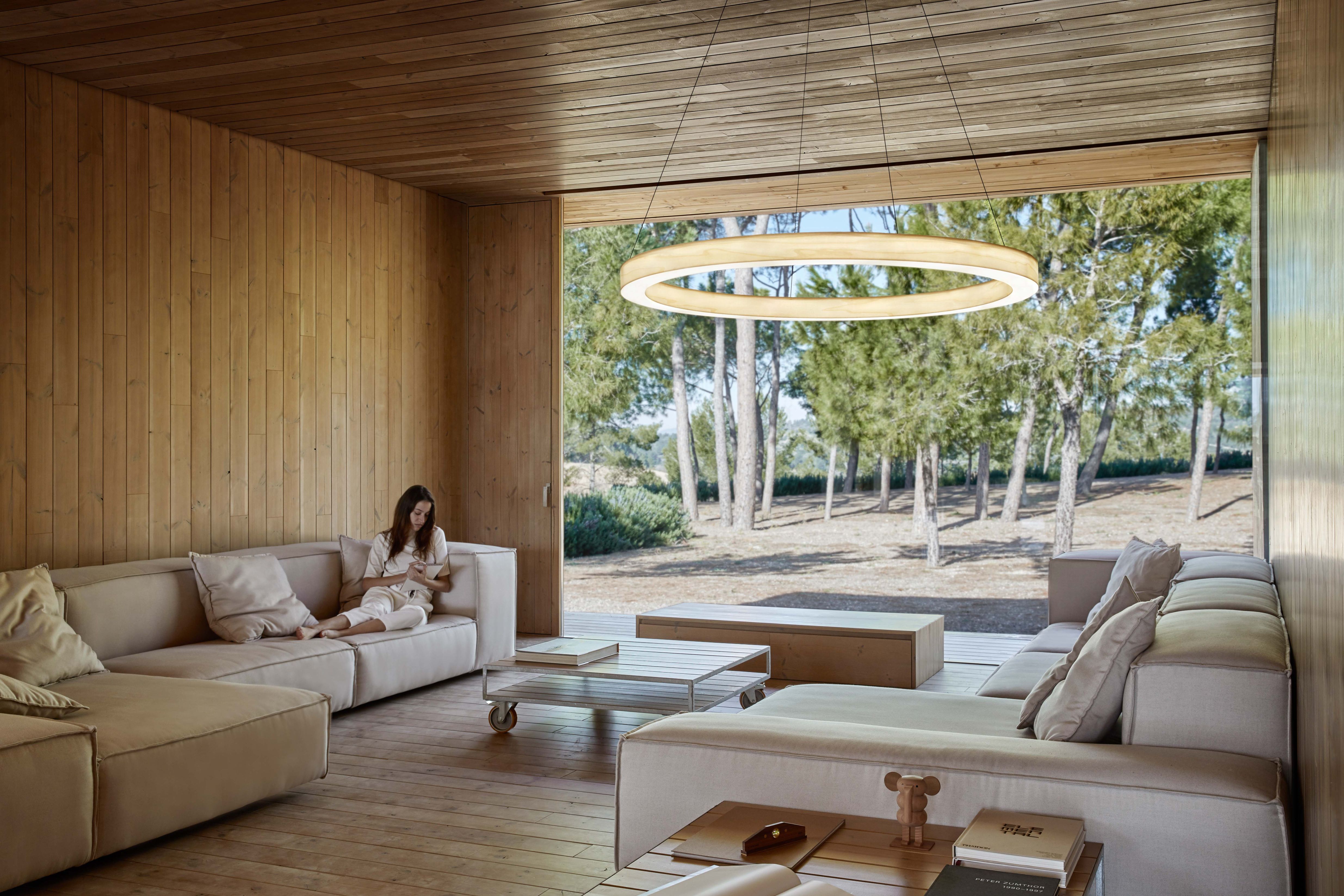 Oh!-Line Pendelleuchte von LZF Lamps in modernem Wohnraum mit Frau auf Sofa.