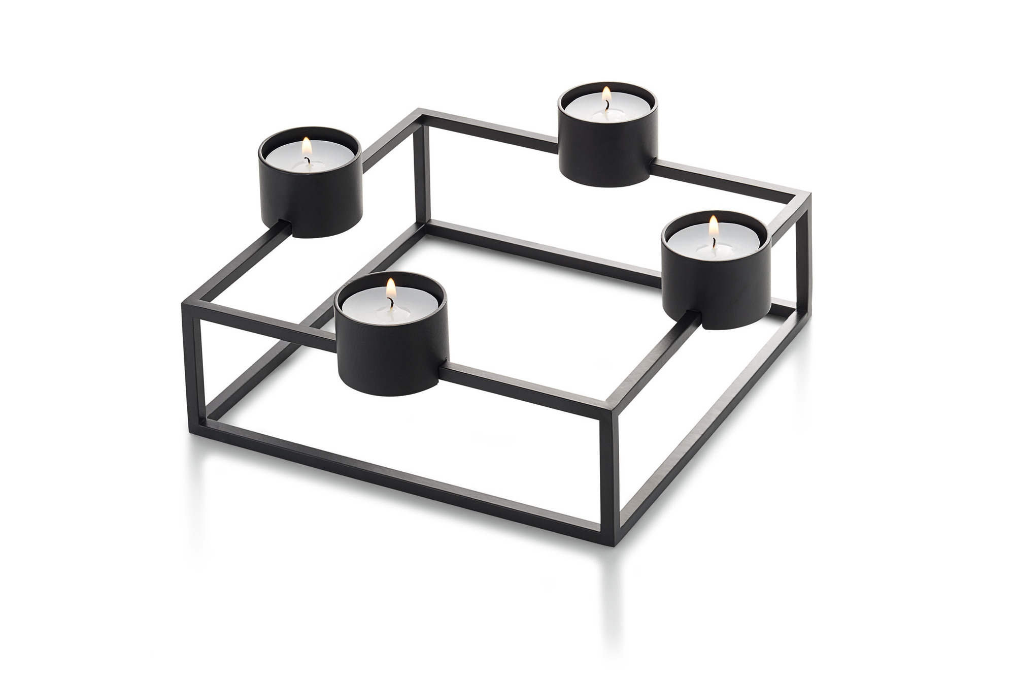Schwarzer Cubo Kerzenhalter von Philippi mit vier brennenden Teelichtern in modernem, quadratischem Design.