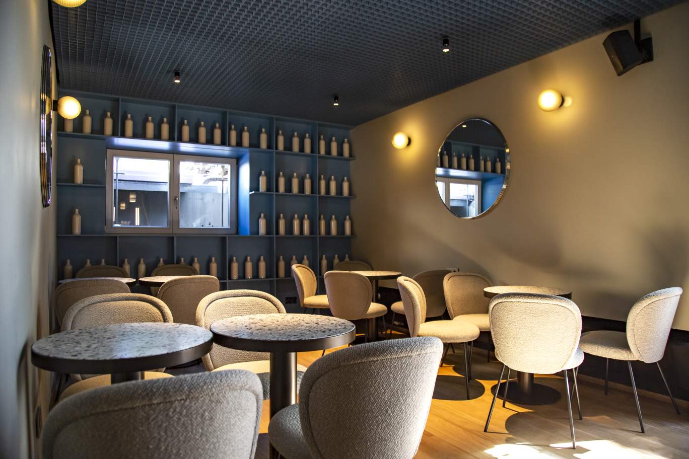 Innenraum mit Stellar Wandleuchten. Auberginefarbene Wandlampen spenden warmes Licht im Raum. Pulpo Leuchten.