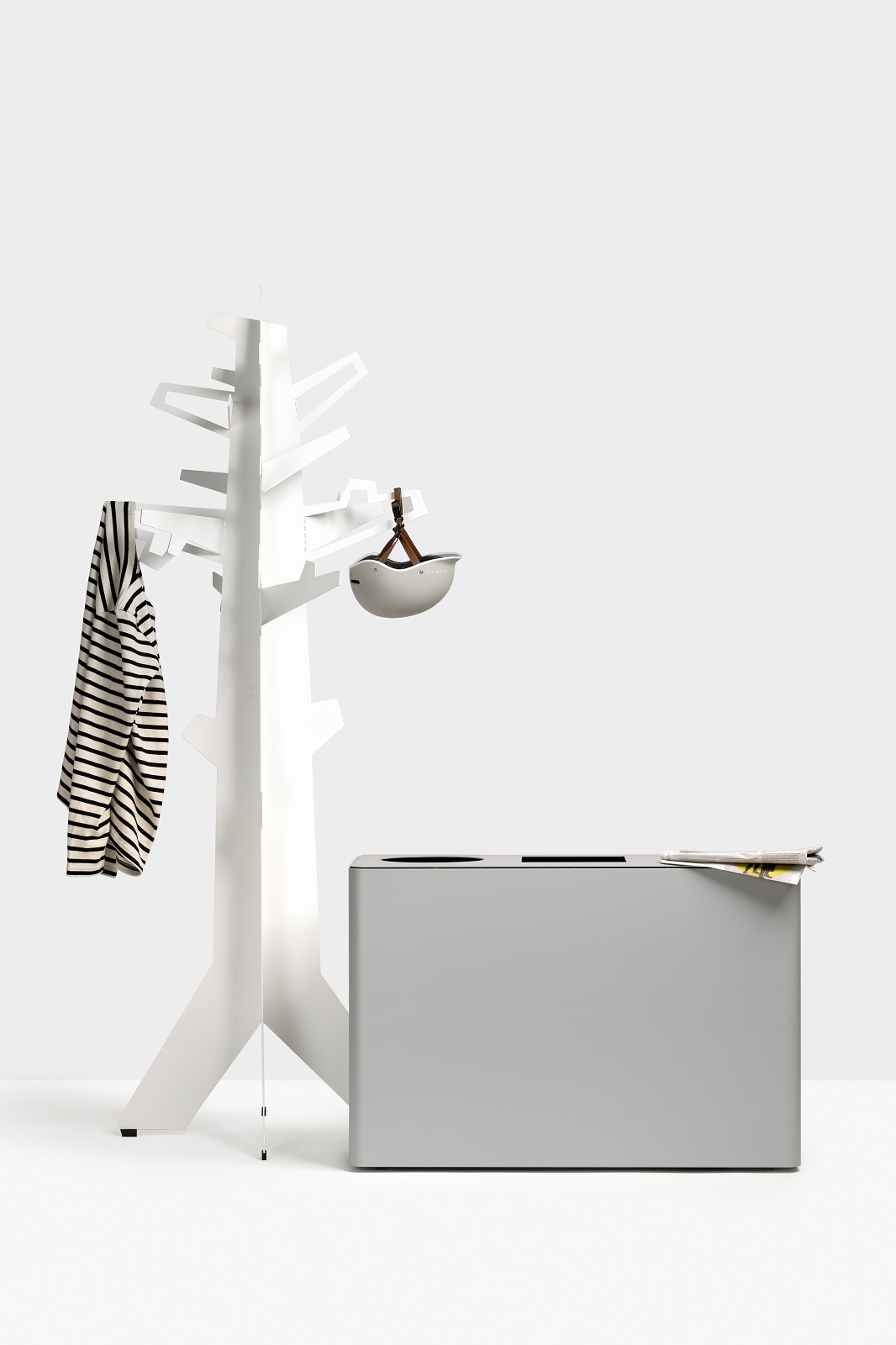 Dunk 3 Abfalltrennsystem: Grauer Mülleimer mit zwei Fächern neben weißer Garderobe mit Kleidung.