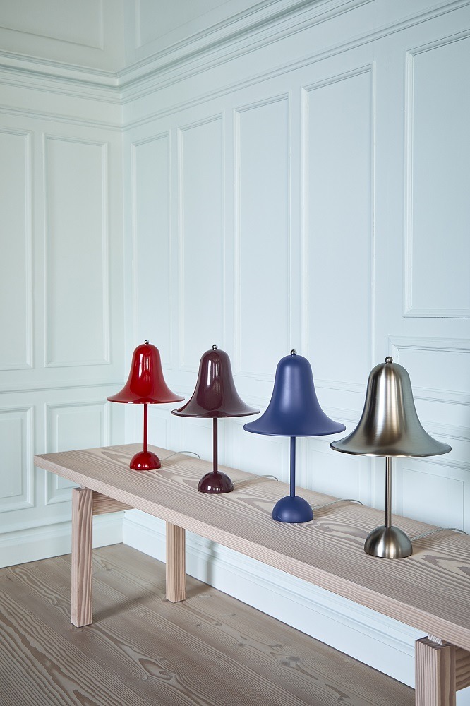 Vier farbige Pantop Tischleuchten von Verpan auf einer Holzbank vor einer weißen Wand.