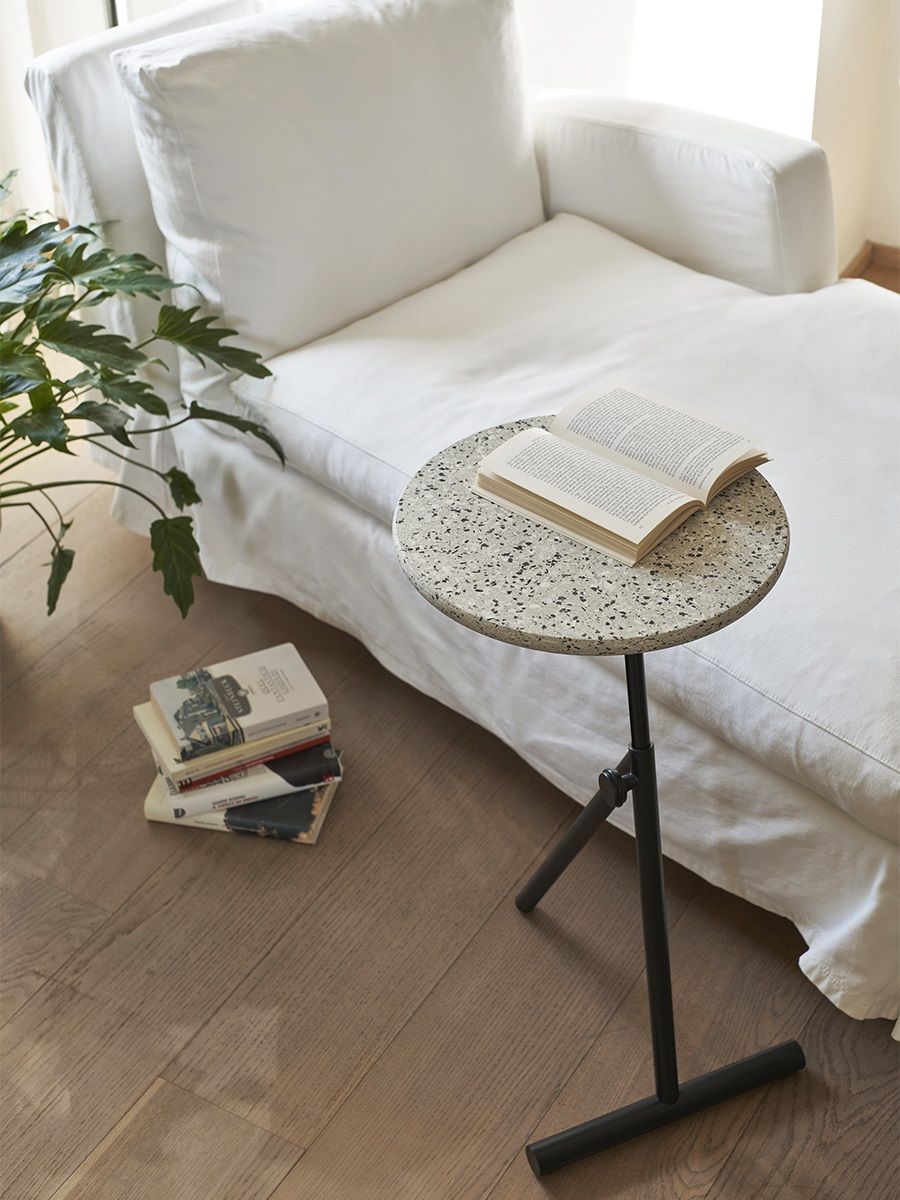 Koji Coffee Table Beistelltisch von Opinion Ciatti mit Buch neben weißer Couch.