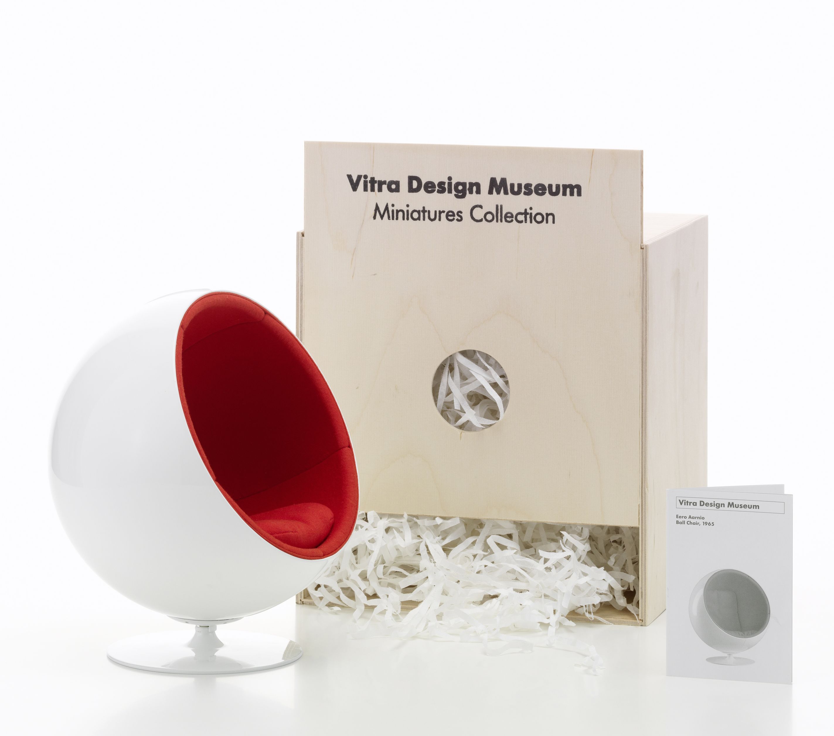 Miniatur des Vitra Ball Chair mit roter Innenausstattung und Holzkiste der Vitra Design Museum Collection.