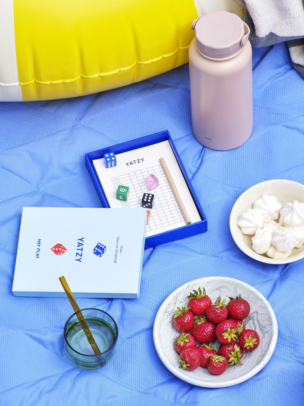 Play Yatzy DE Blau Hay Spiel mit Würfeln, Erdbeeren und Getränken auf einer blauen Picknickdecke.