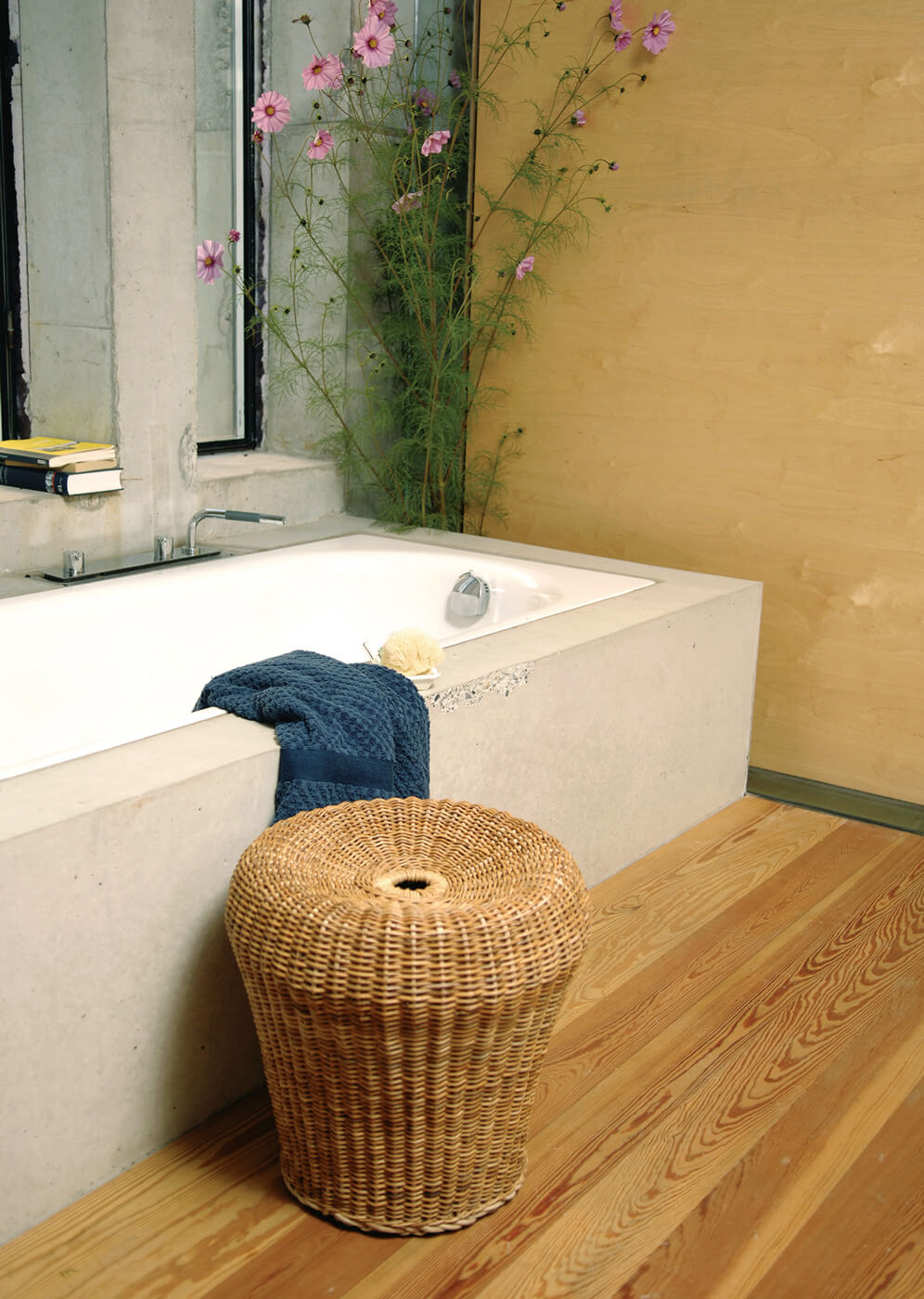 E14 Rattanhocker von Richard Lampert im Badezimmer neben Badewanne und Holzboden.